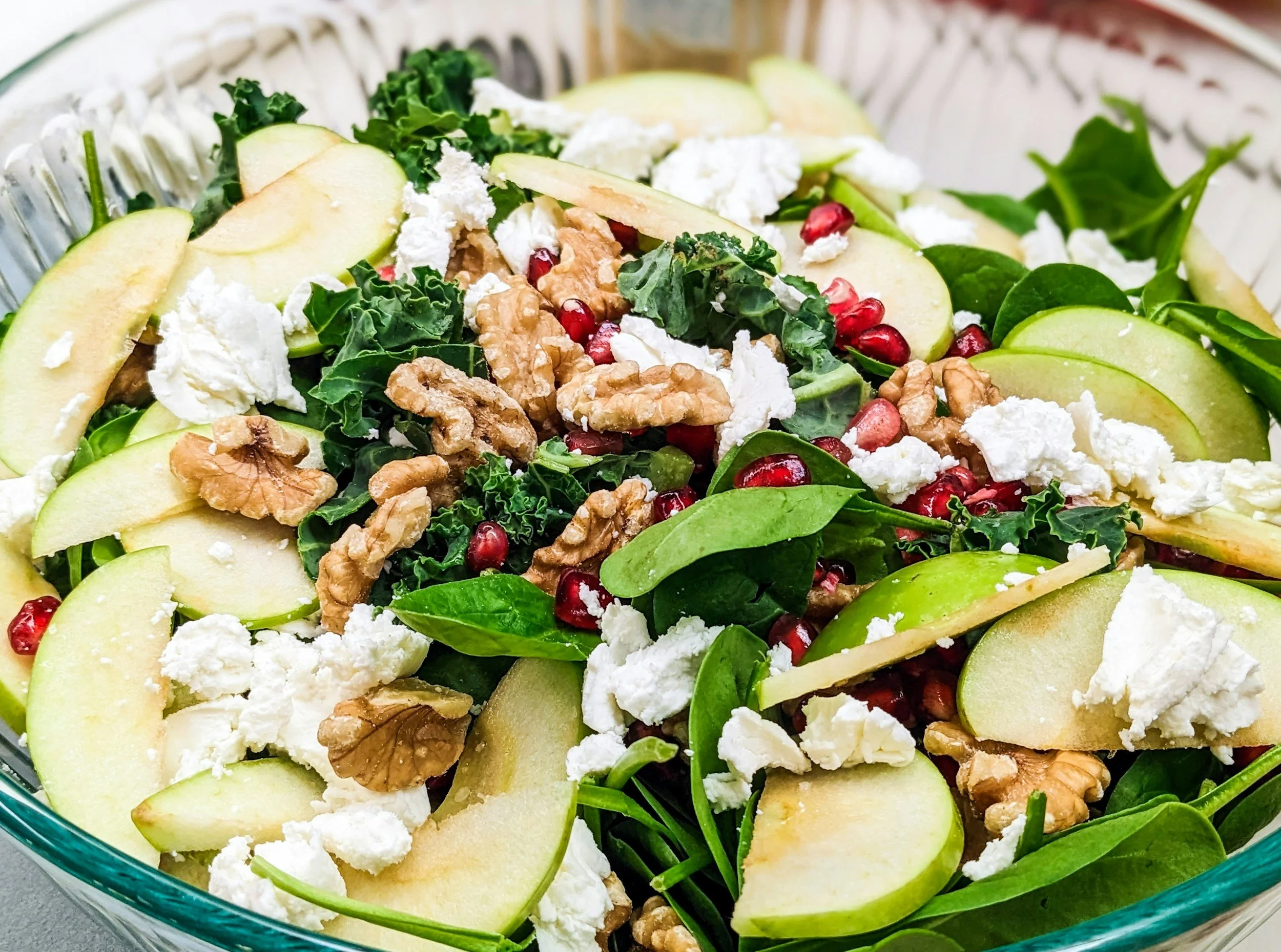 Green salad with sliced apples, walnuts and crumbled white cheese