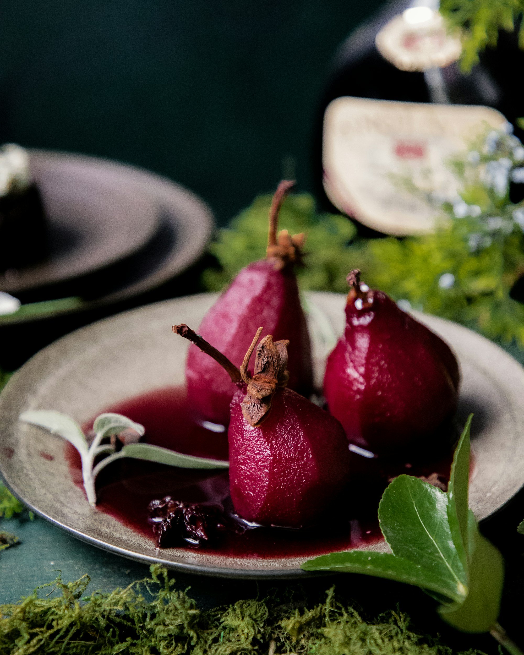 Deep red poached pears served in syrup with a creamy accompaniment