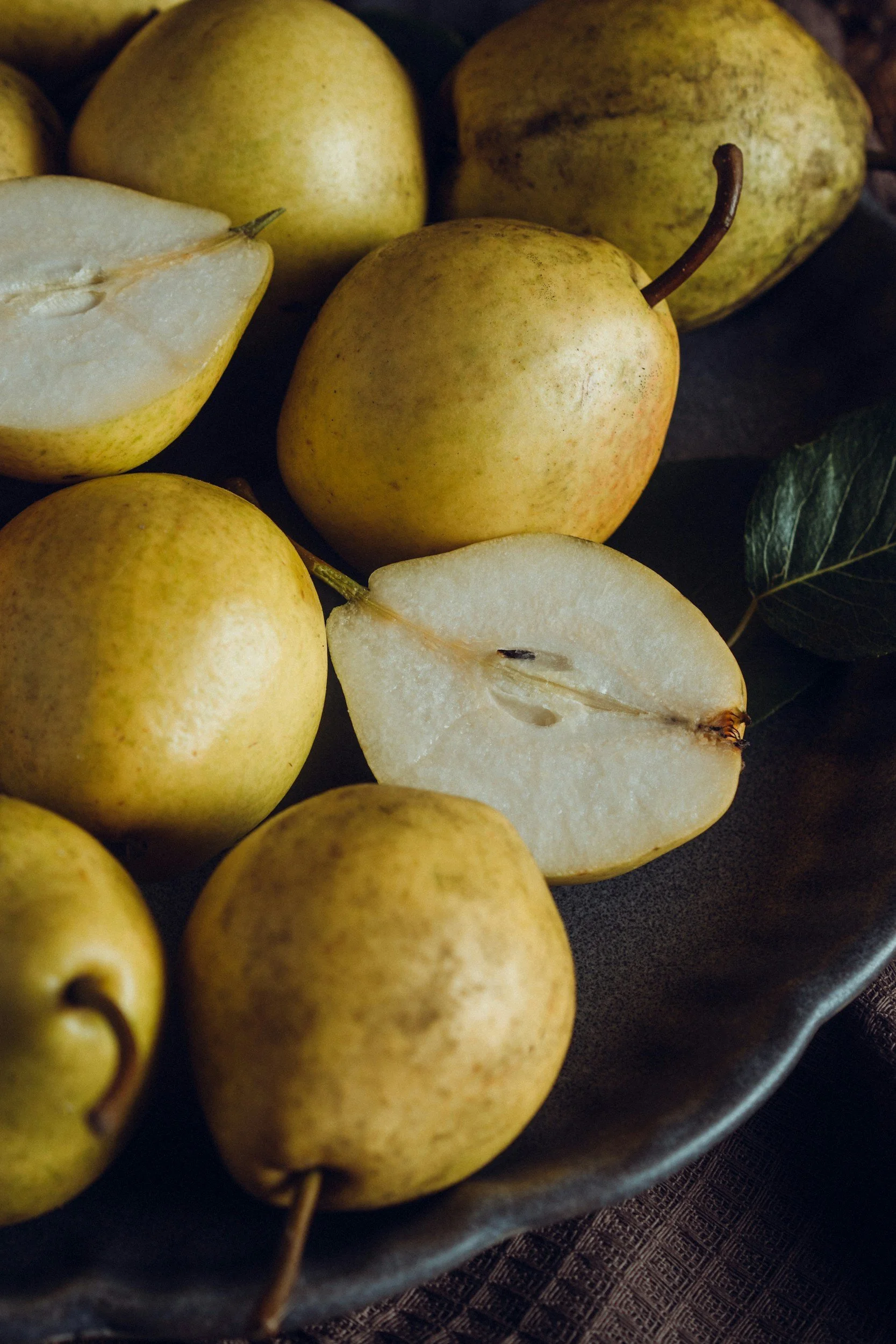 Whole pears and a cut pear showing the pale flesh