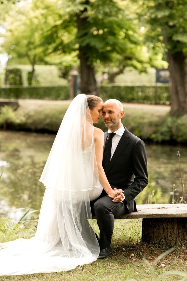 Gezicht op een landschap met groene heuvels en moderne gebouwen, met op de achtergrond besneeuwde bergpieken onder een bewolkte hemel.