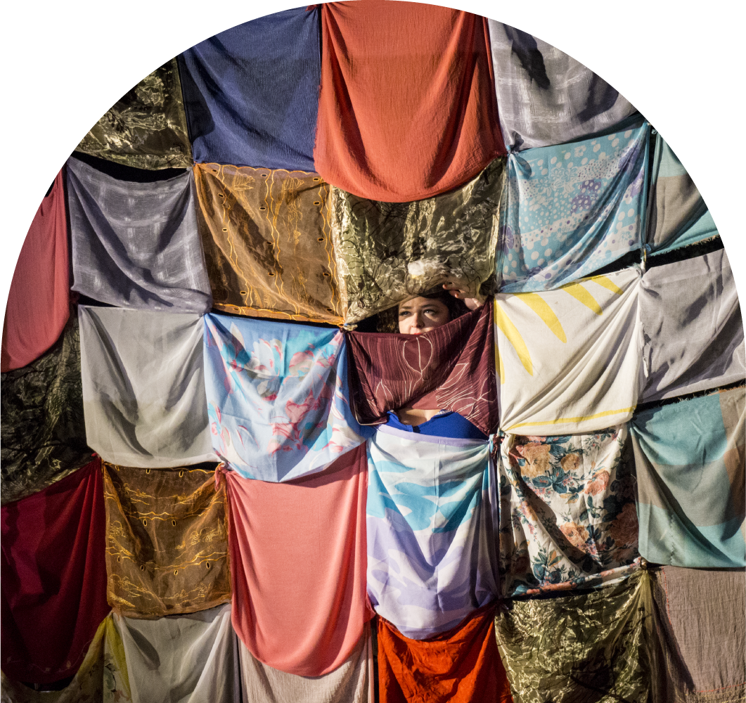 A performer on stage peeking through the back curtain.