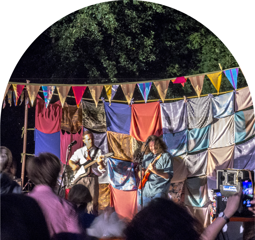 Two musicians performing on an outdoor stage.