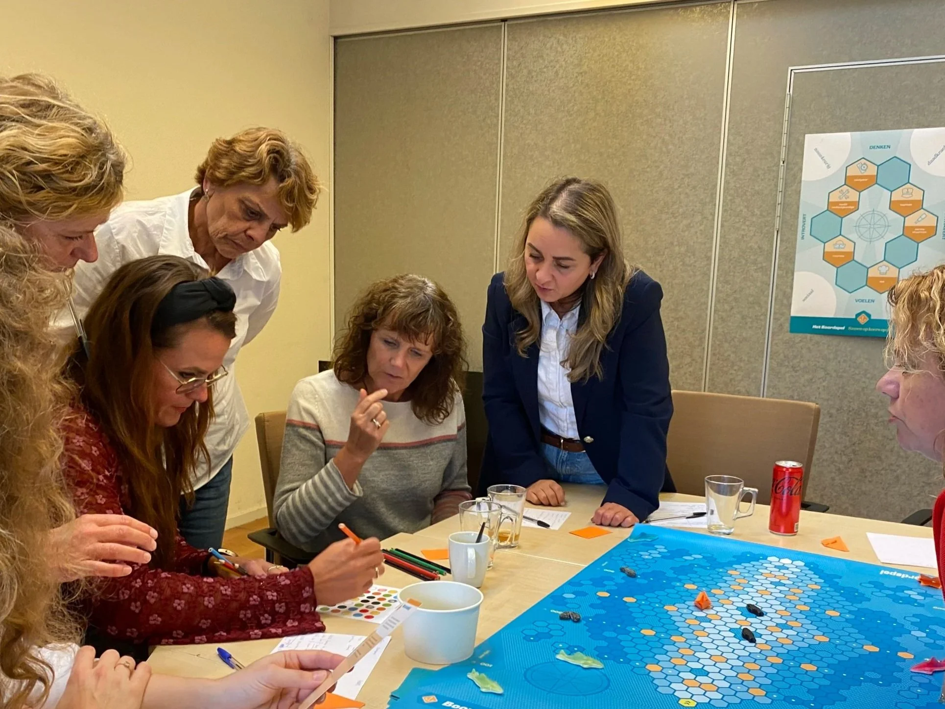 Groep collega's die het Boordspel spelen en bezig zijn met een opdracht.