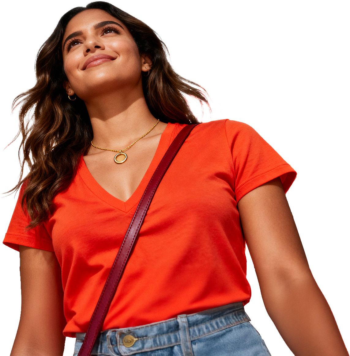 Mulher sorrindo com blusa vermelha, jeans e bolsa vermelha, usando colar dourado, acessório de cabelo, cabelo cacheado e solto.