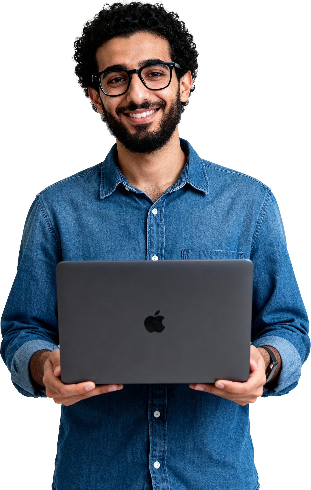 Homem com barba, óculos pretos, sorrindo, segurando um laptop MacBook cinza, vestindo camisa jeans azul, fundo transparente.