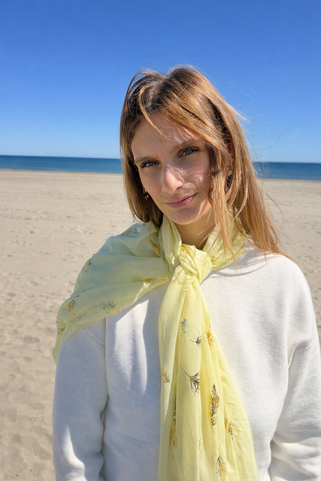 Femme au bord de mer avec écharpe jaune.png