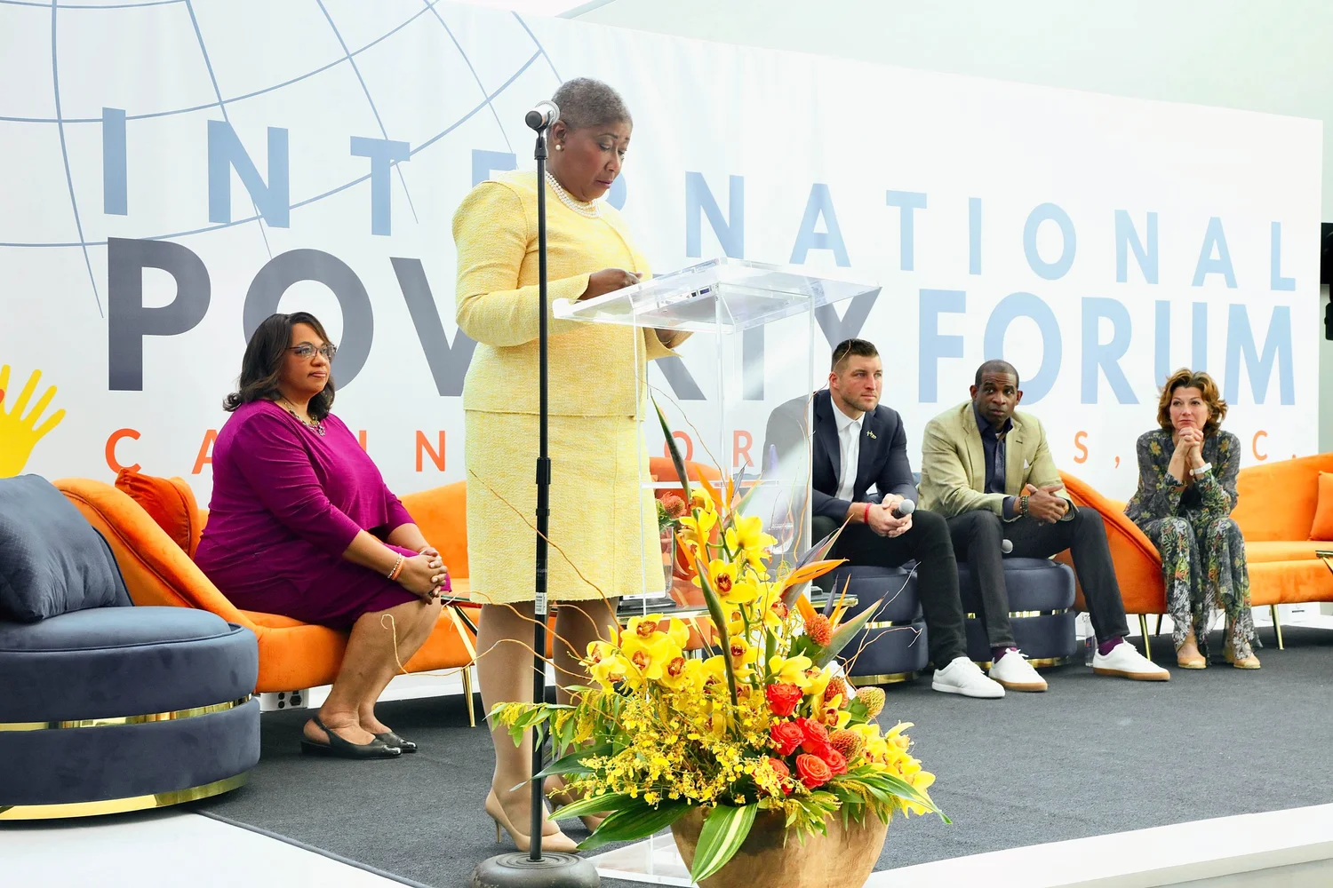 A speaker addresses the Assembly from the podium beside a panel