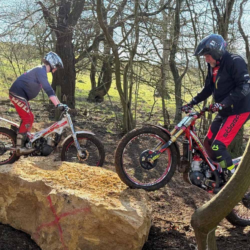 Riders practising on rock obstacles at Magnum Trials Centre motorcycle trials venue.