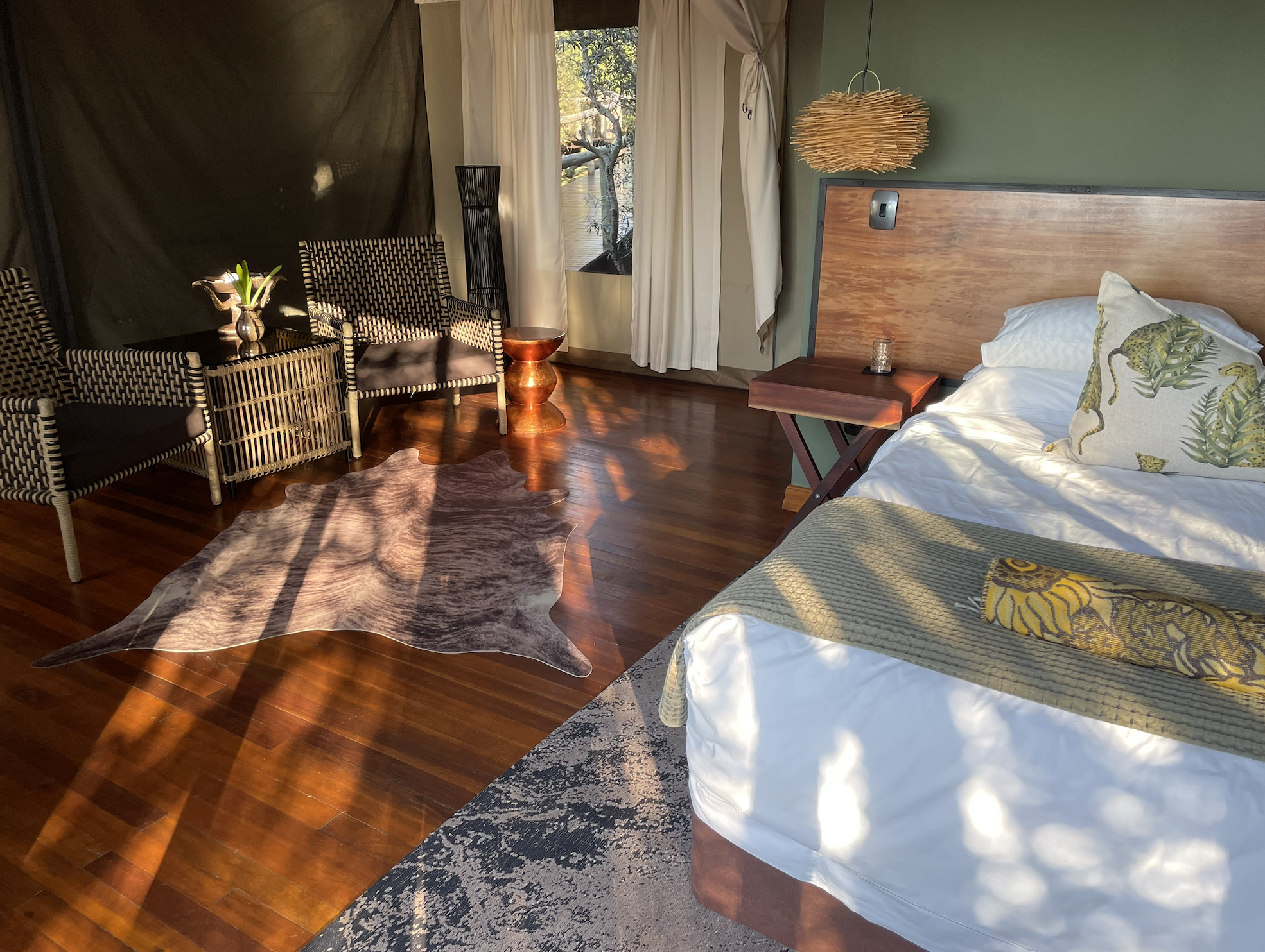 Eco-lodge bedroom with neutral tones and views of the surrounding bush.