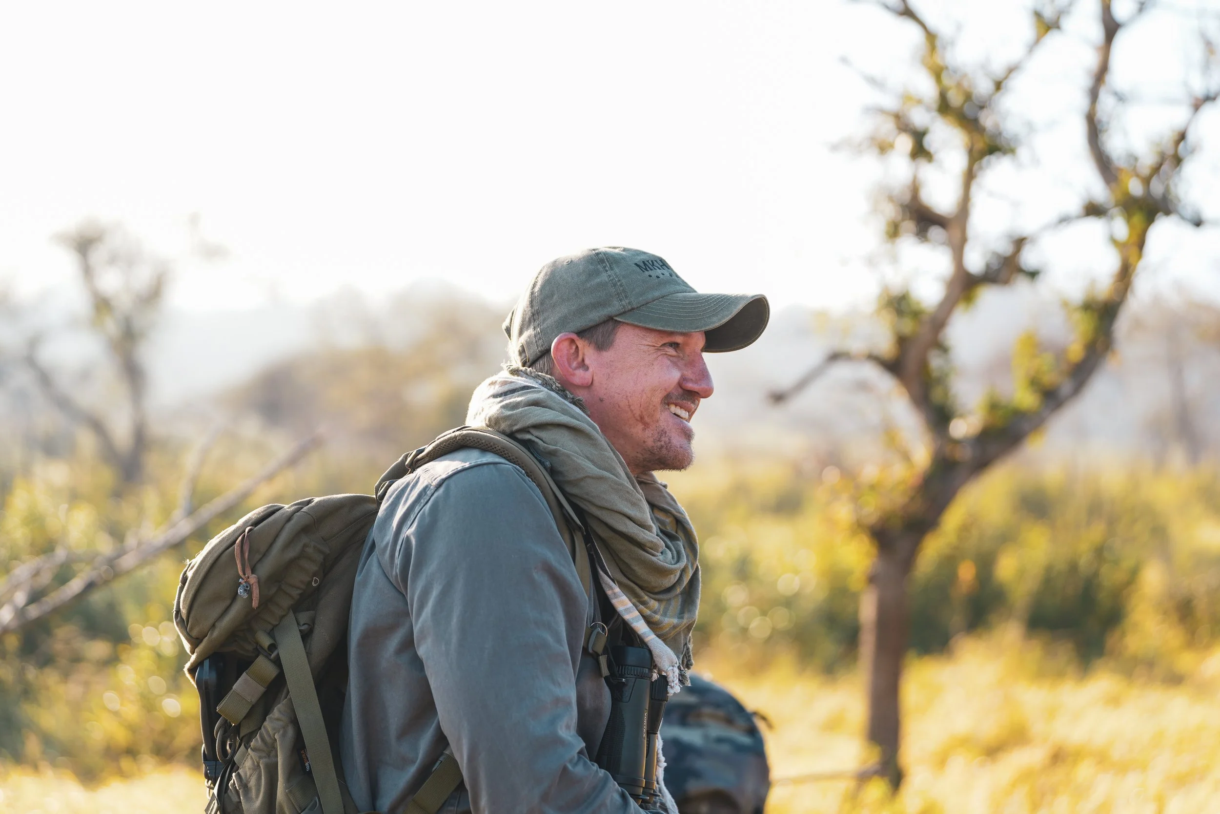 Honey Guide trails guide walking through the Zululand bush during a wildlife tracking operation.