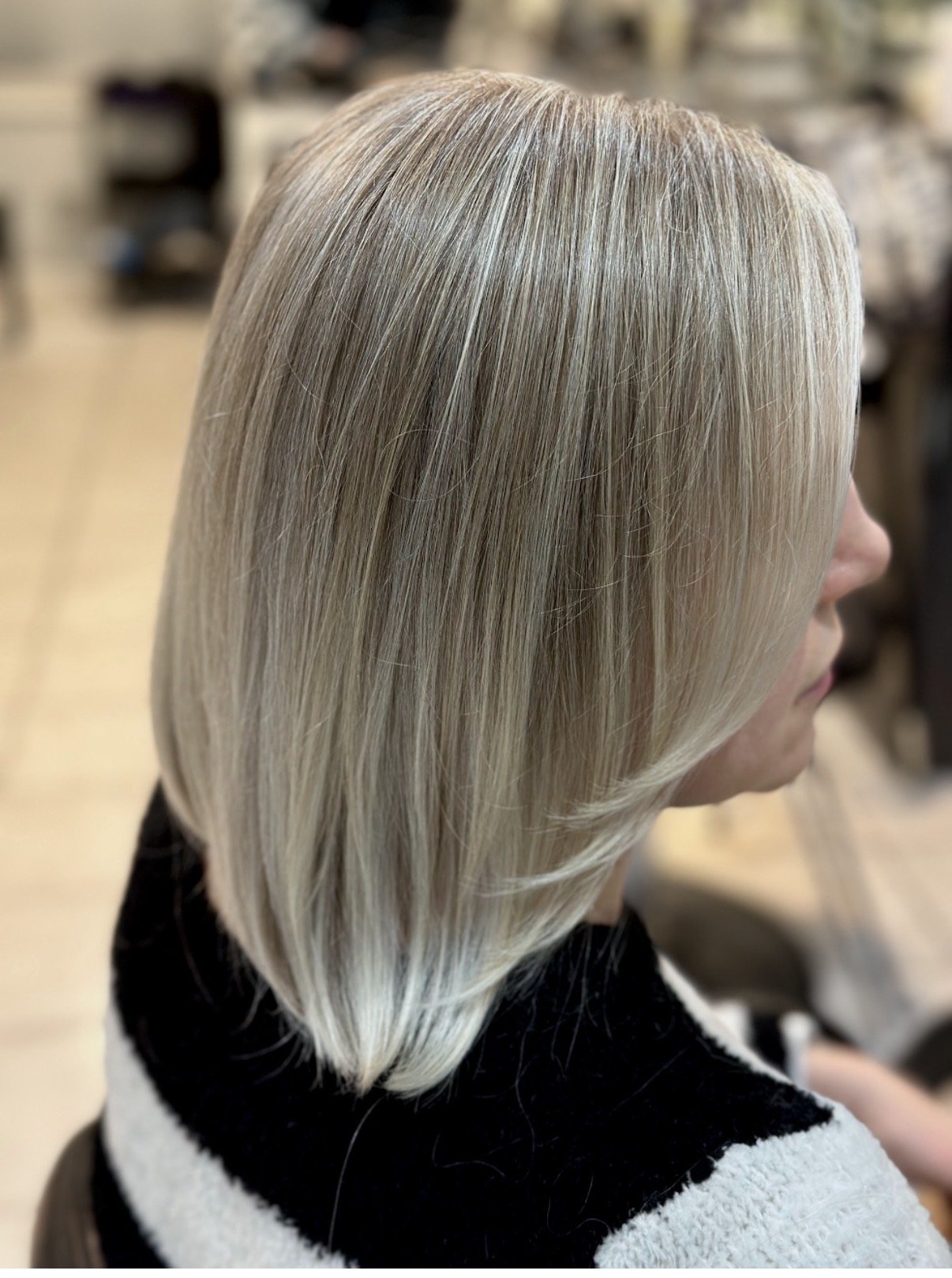 Side view of a woman with shoulder-length, straight, platinum blonde hair.