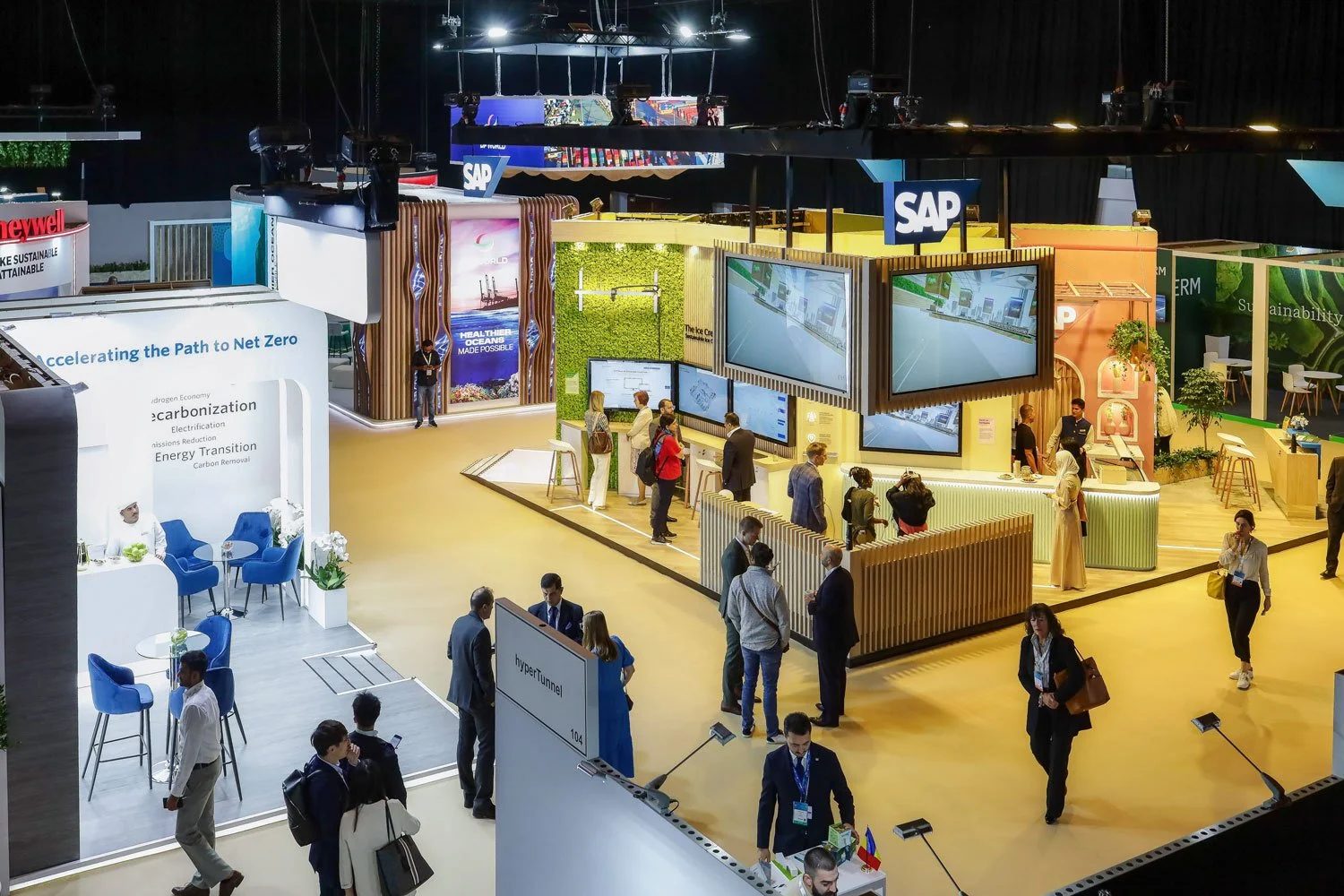 Trade show visitors exploring exhibition stands and networking at a business event.