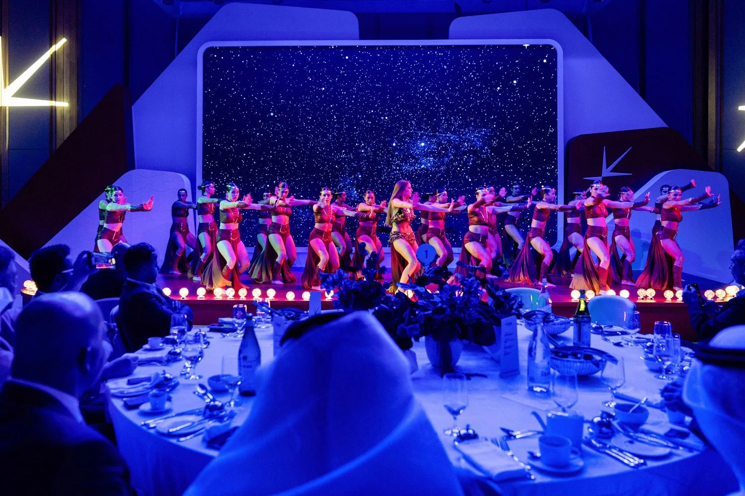 Large stage performance during a corporate gala event with live dancers and audience in Dubai.