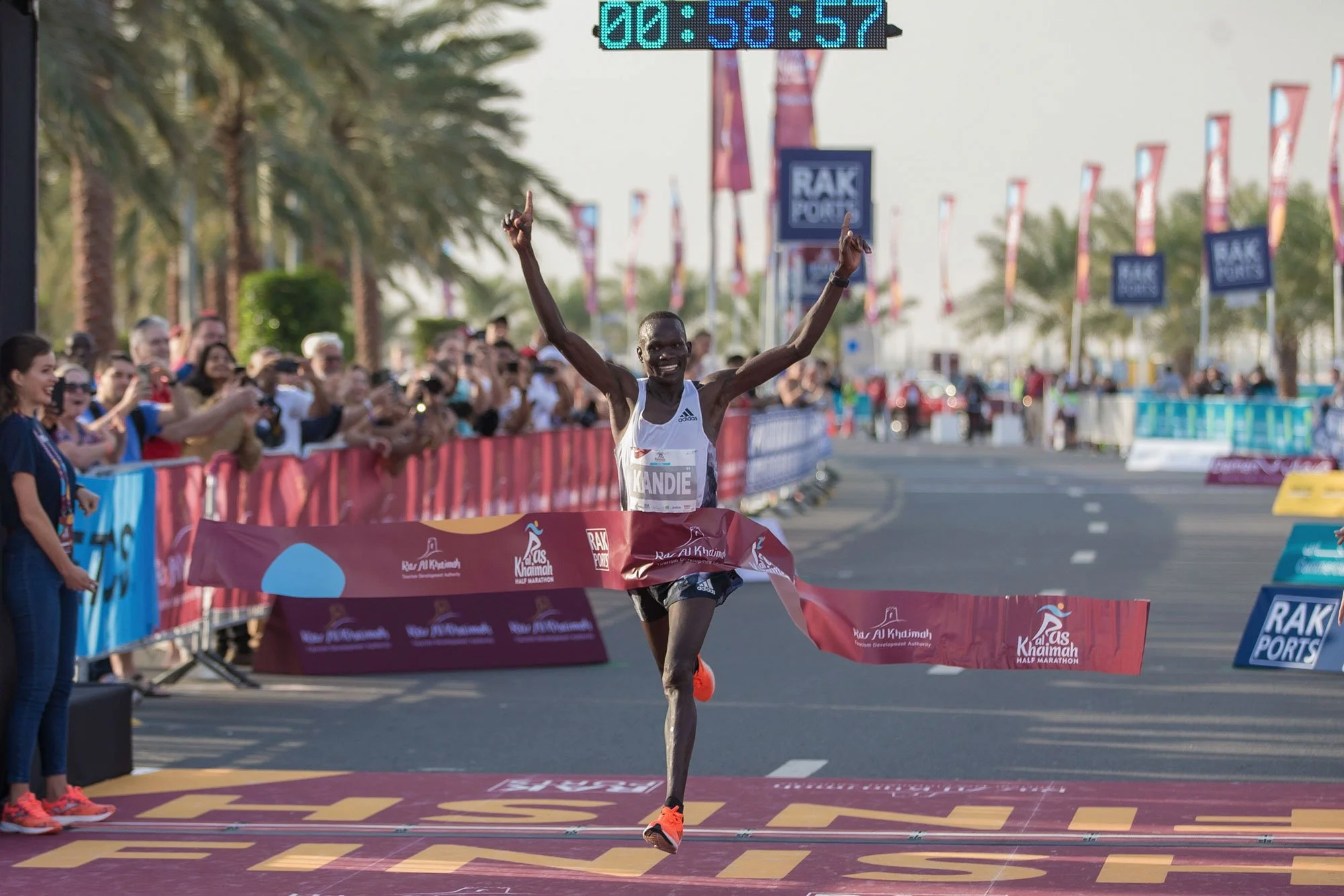 Marathon runner crossing the finish line during an international road race event in Ras Al Khaimah.