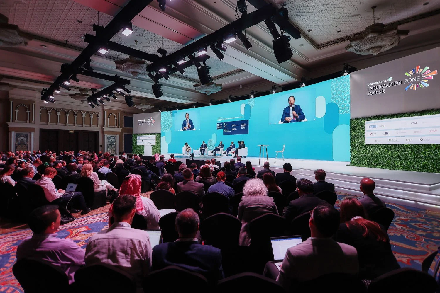 Modern conference stage design with circular lighting installation during a global business forum.