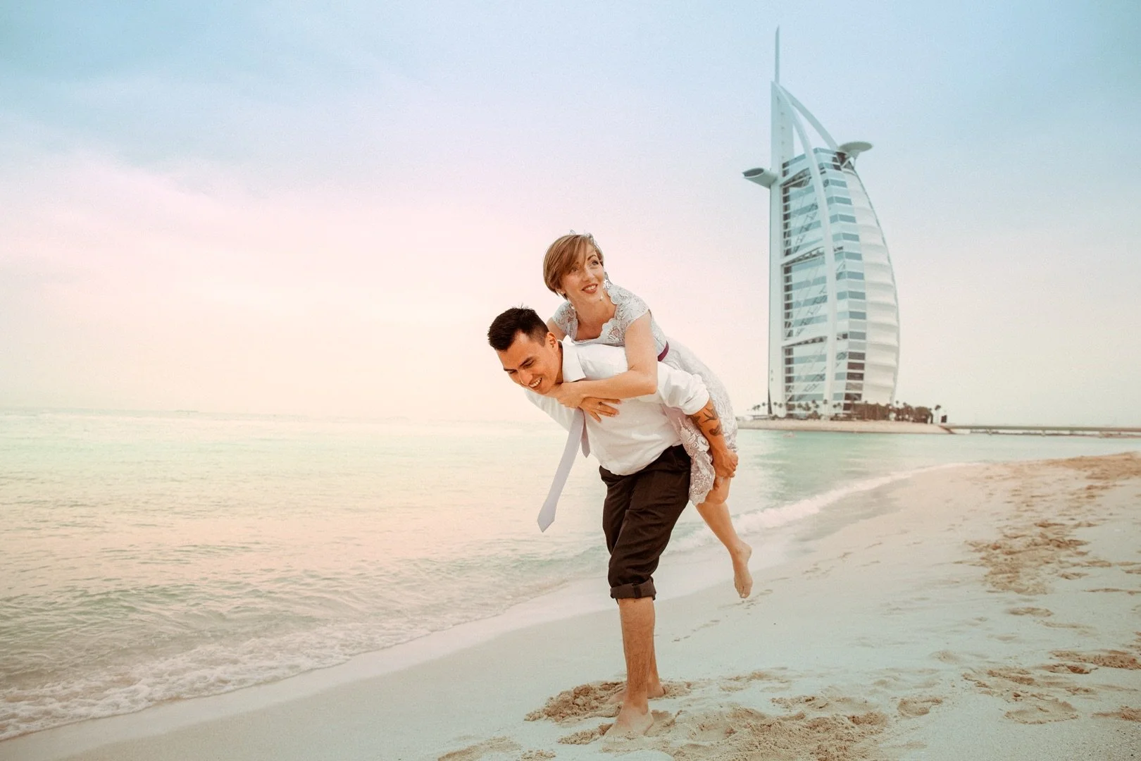 Lifestyle couple photography in Dubai, photographed on the beach with the Burj Al Arab in the background. Natural, candid people photography