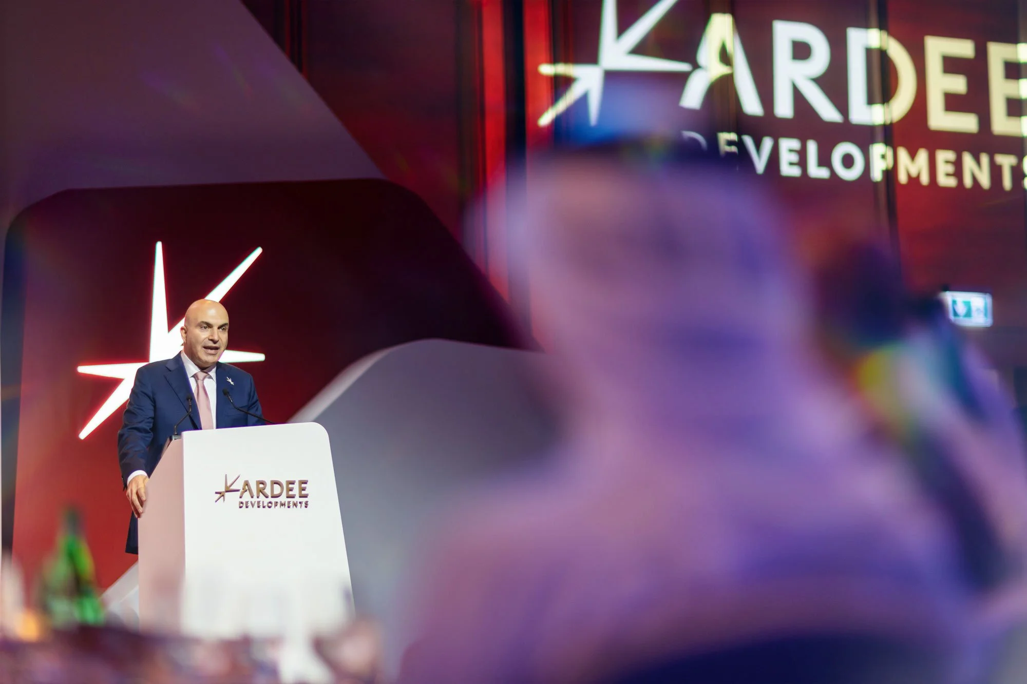Executive speaker presenting during international business summit.