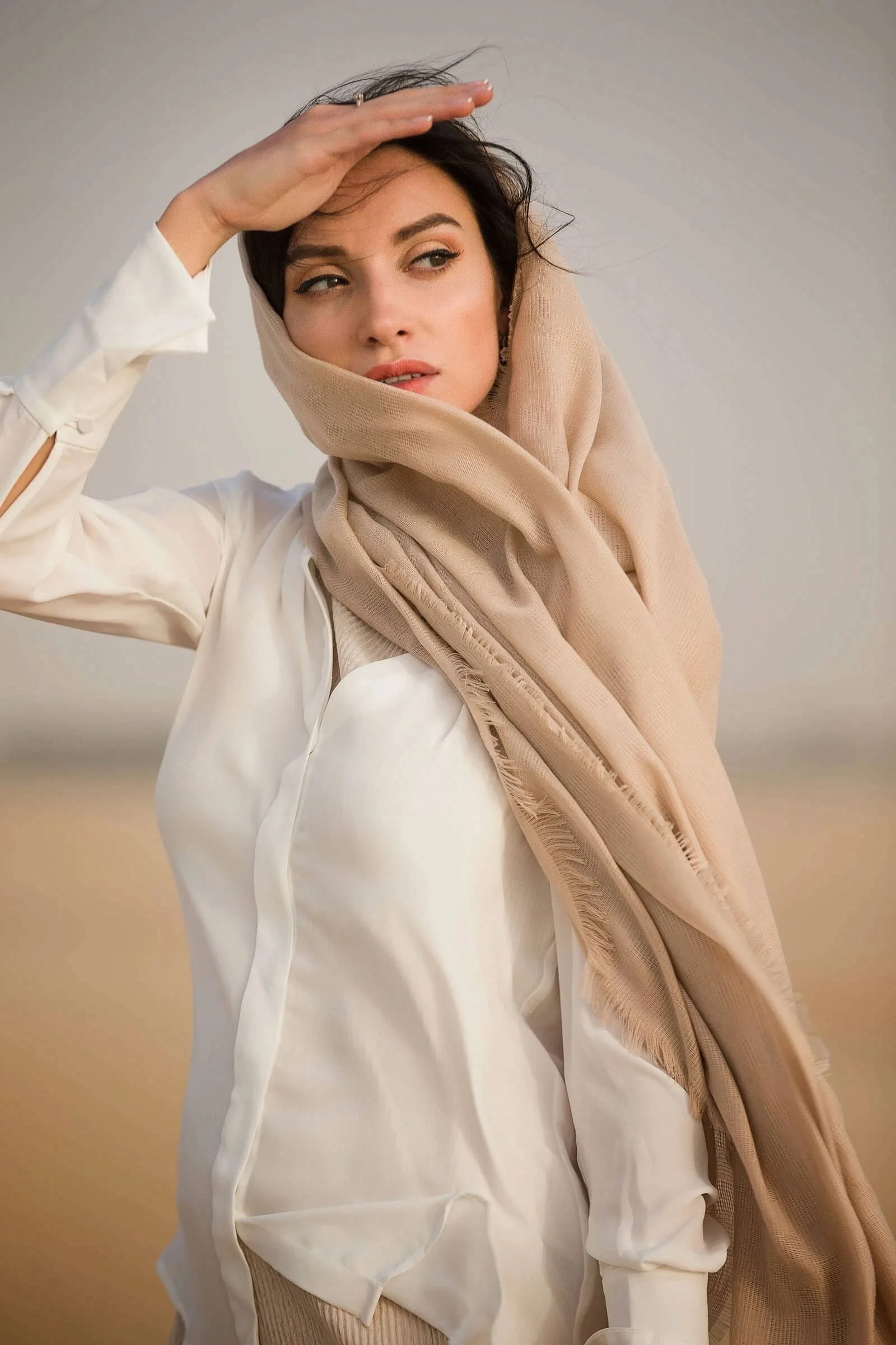 Lifestyle portrait of woman walking in desert landscape photographed in Dubai for fashion and lifestyle photography.