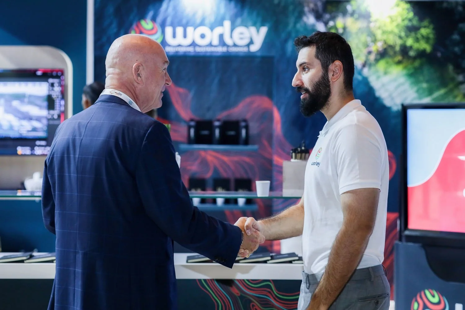 Visitors networking at a technology exhibition booth during a trade show in Dubai.