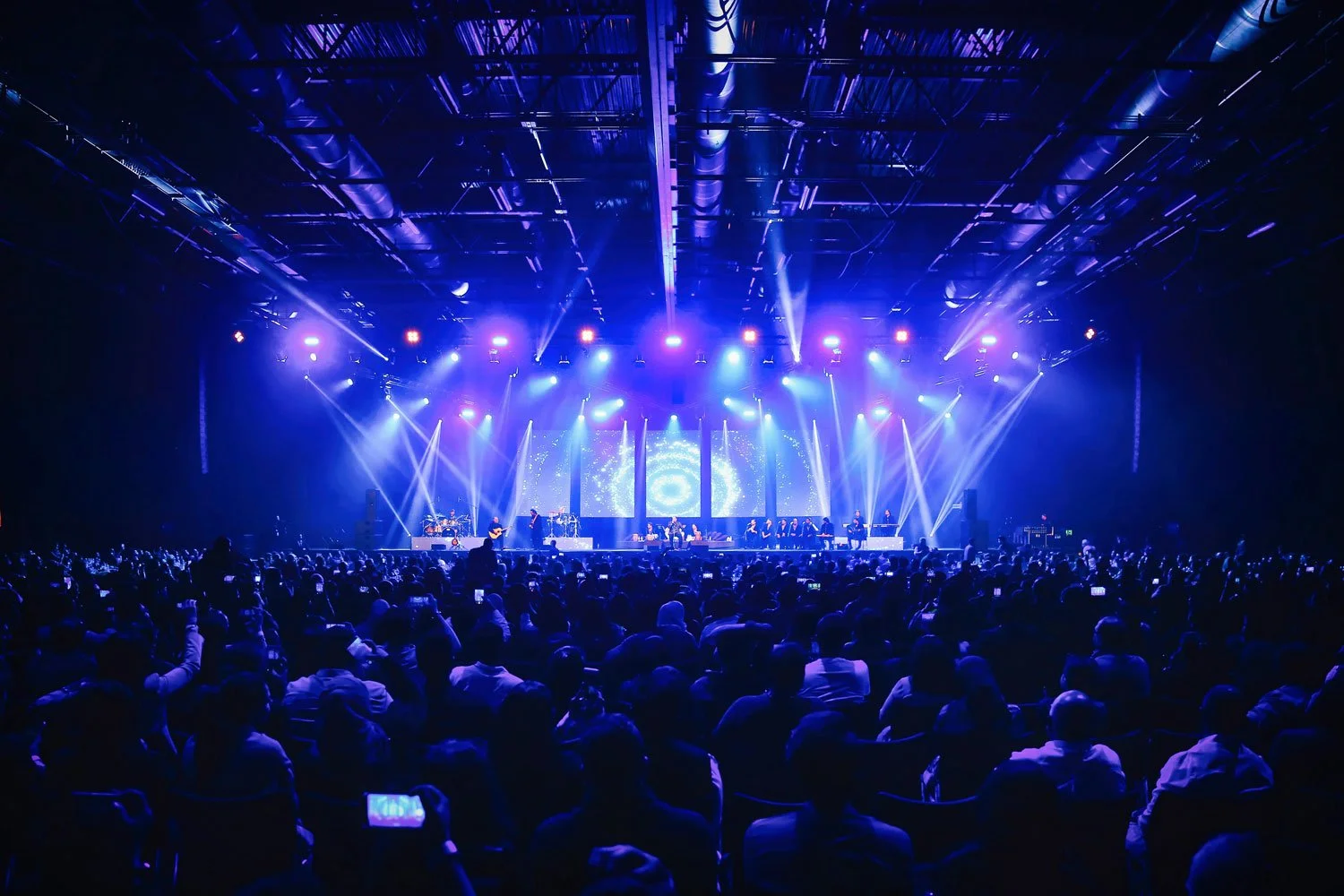 Live concert performance on stage with audience and professional stage lighting during a corporate entertainment event.