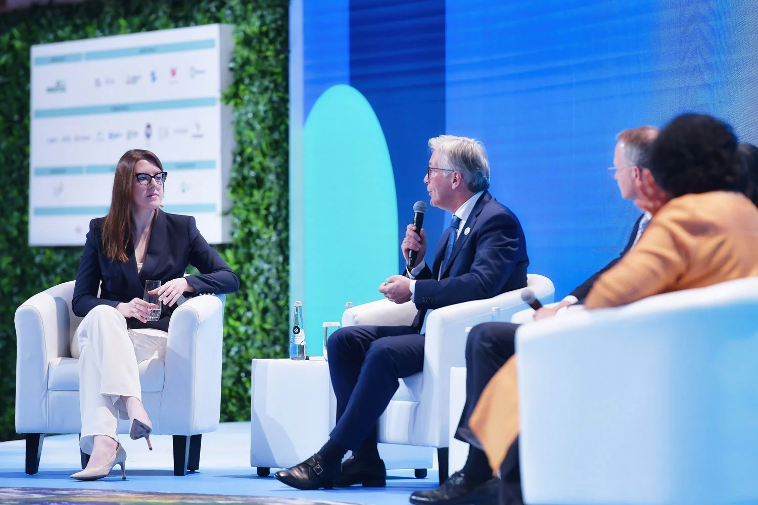 Panel discussion between industry leaders at international forum event.