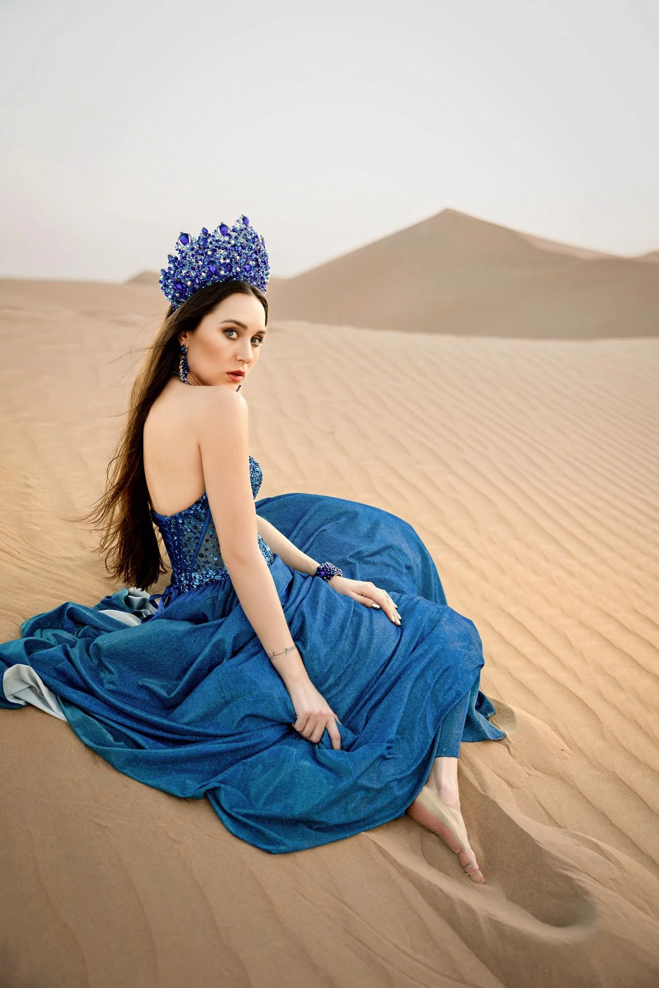 Lifestyle portrait of woman walking in desert landscape photographed in Dubai for fashion and lifestyle photography.