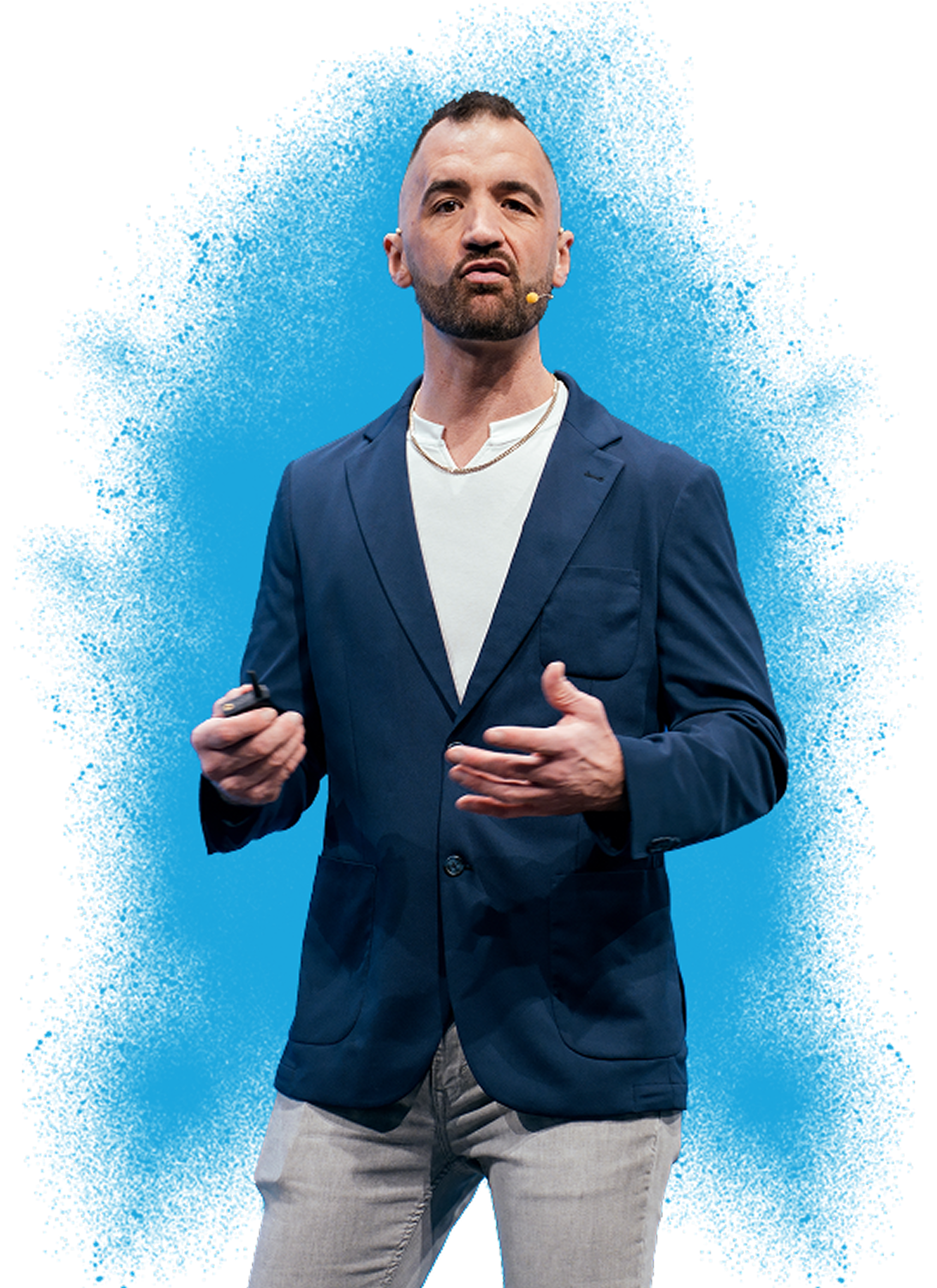 A man in a navy blazer and light-colored pants giving a presentation on stage with a blue background.