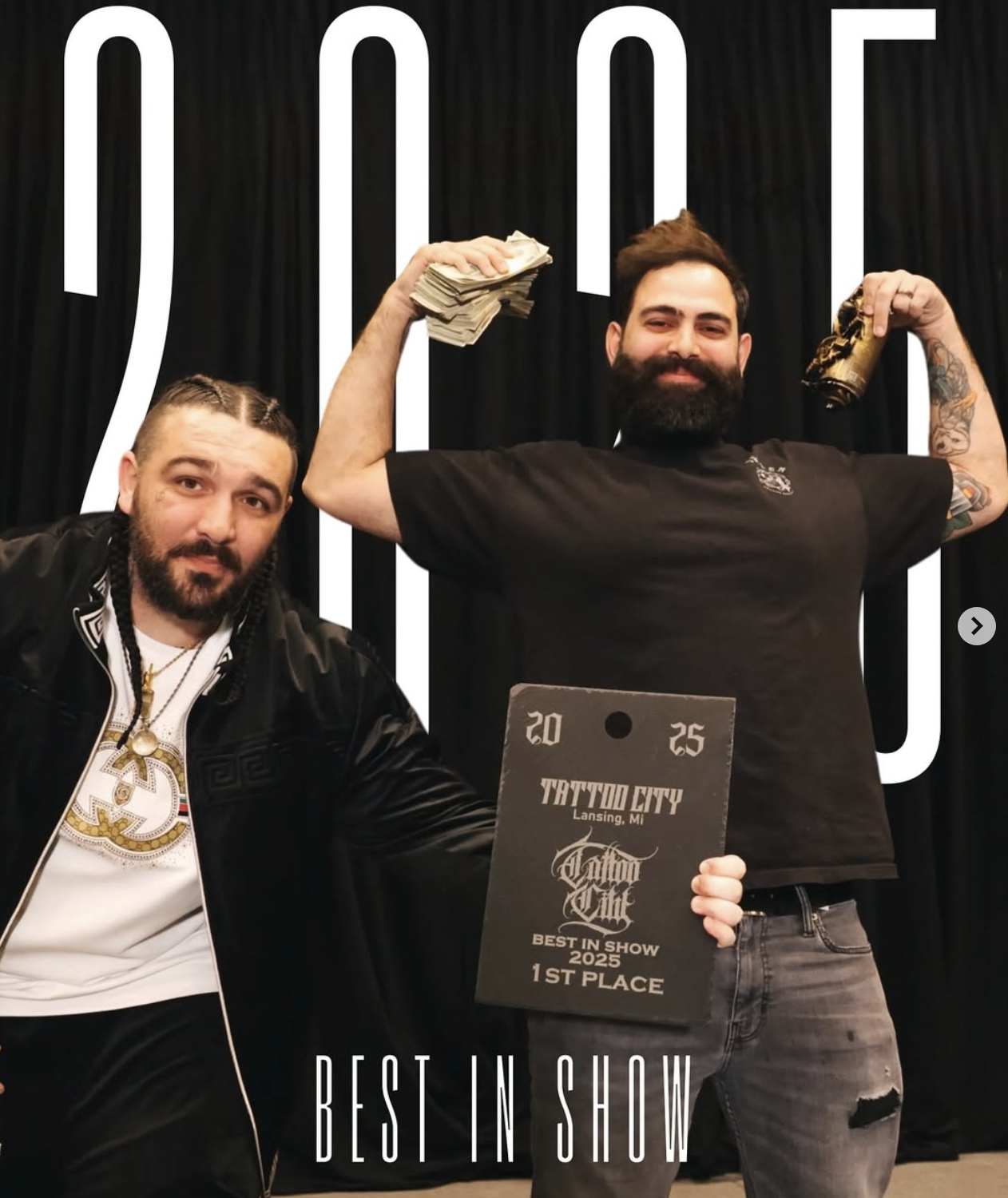 Two men celebrating winning first place at a tattoo convention, one holding a plaque that reads 'Best in Show 2025, 1st Place, Tattoo City Lansing MI,' the other holding stacks of money and a drink, standing in front of a black background with the words 'JOU'