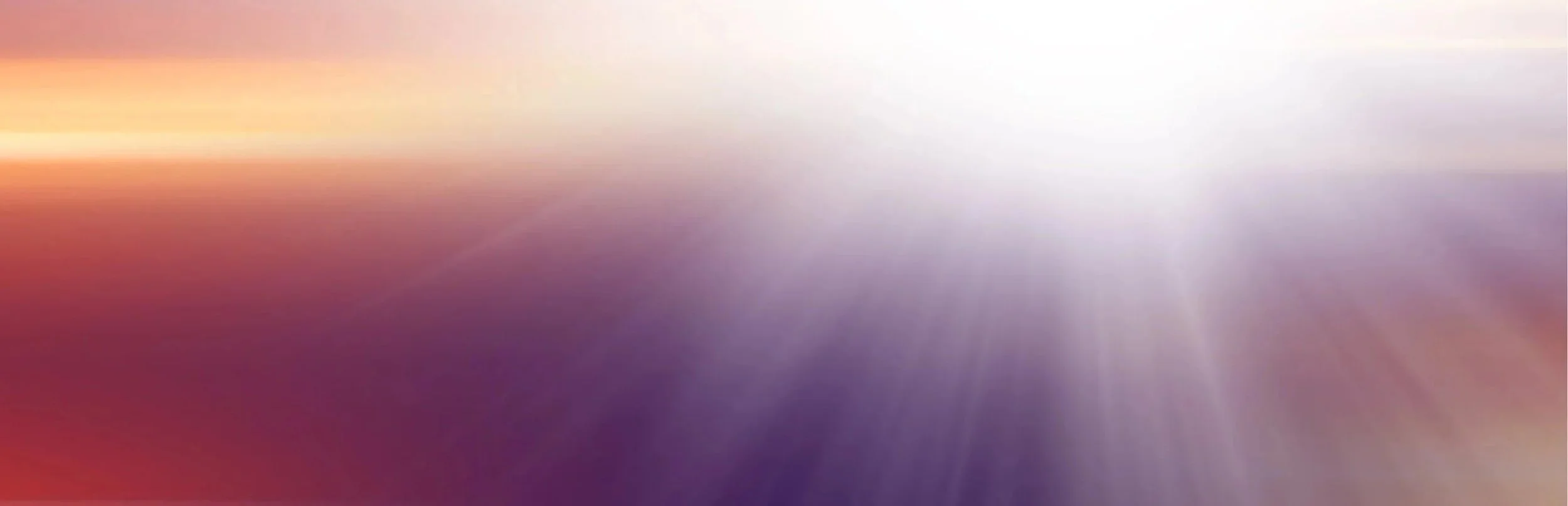Fonds flou avec dégradé de couleurs pastel, mélange de violet, rose, orange et blanc, avec des rayons de lumière douce.