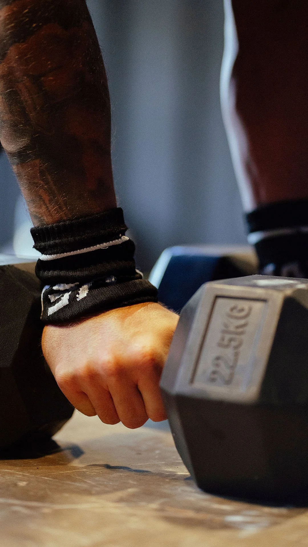 Persona levantando una pesa de 25 kg en un gimnasio.