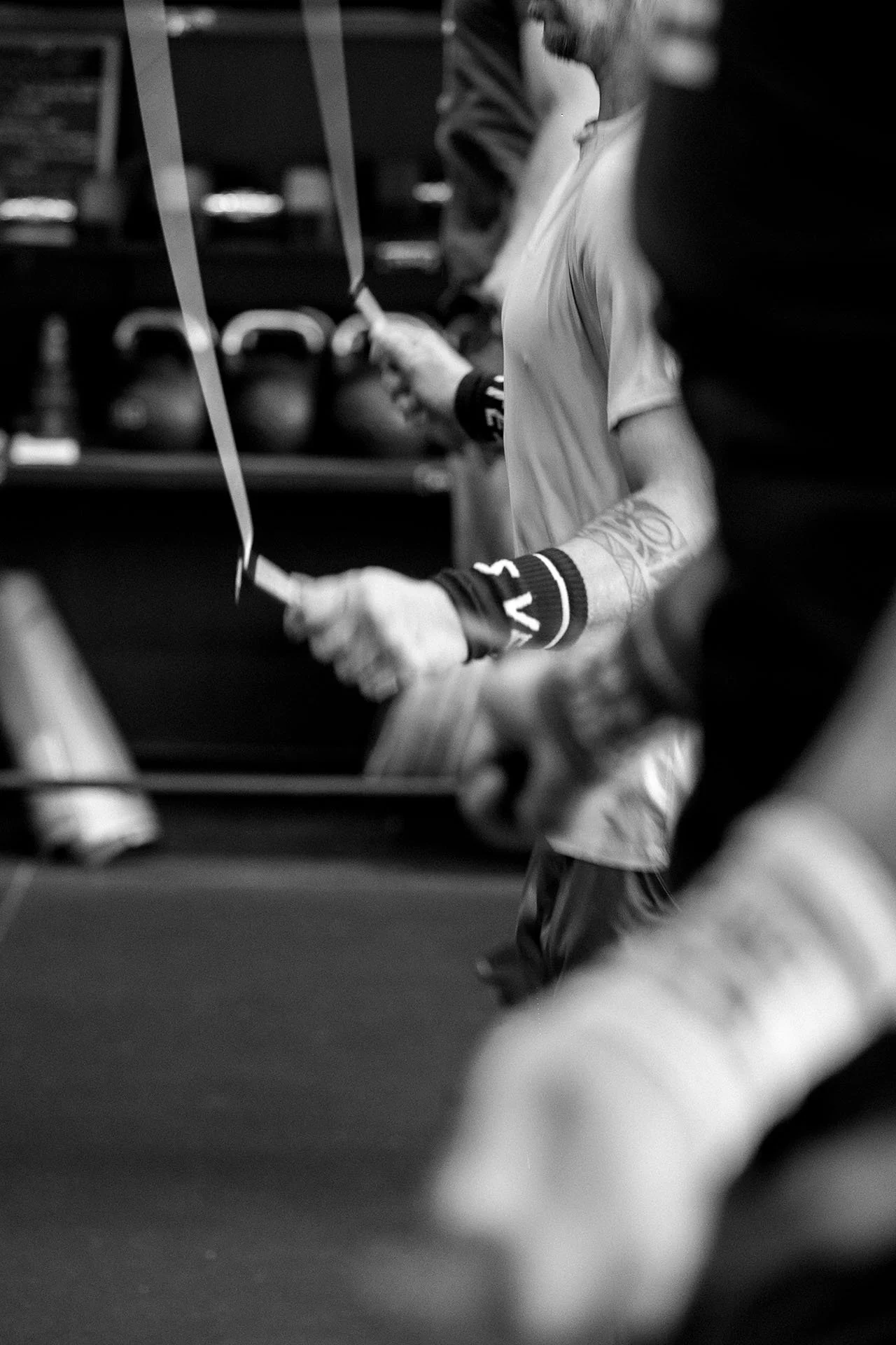 Joven en el gimnasio con guantes de boxeo sosteniendo una cuerda de saltar.