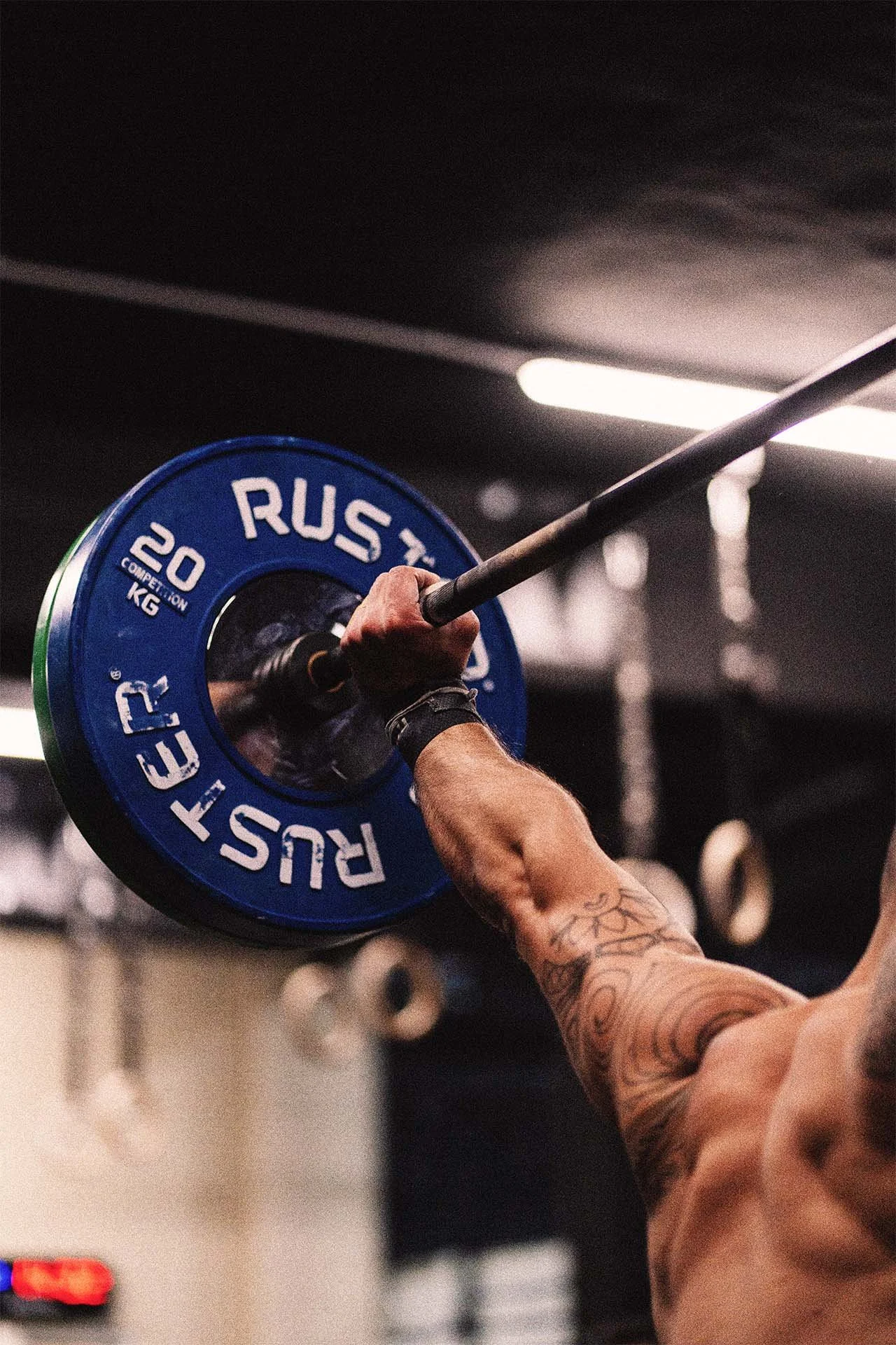 Persona levantando una barra con peso en un gimnasio.