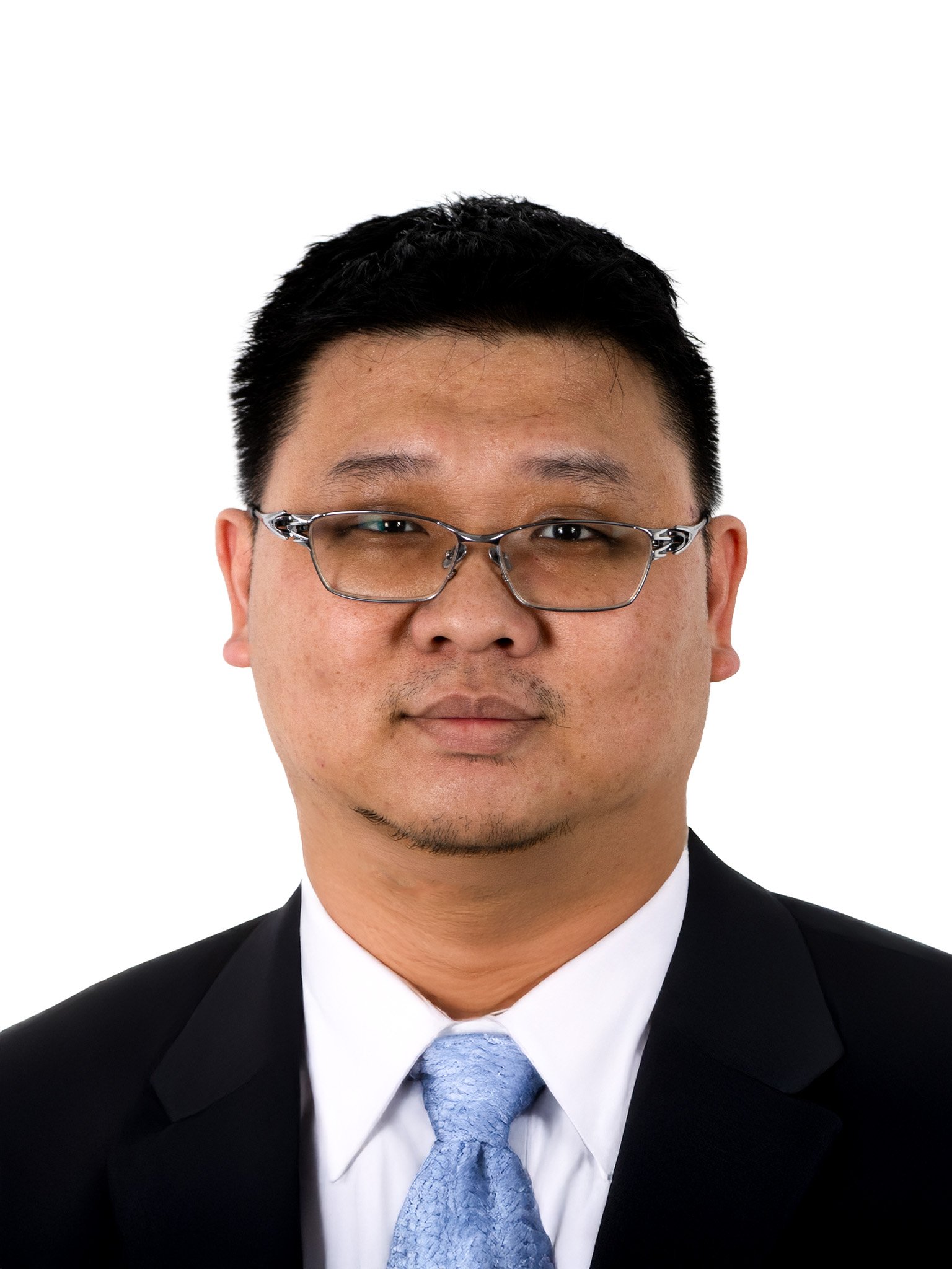 Porträt eines Mannes mit Brille in formaler Kleidung vor weißem Hintergrund.