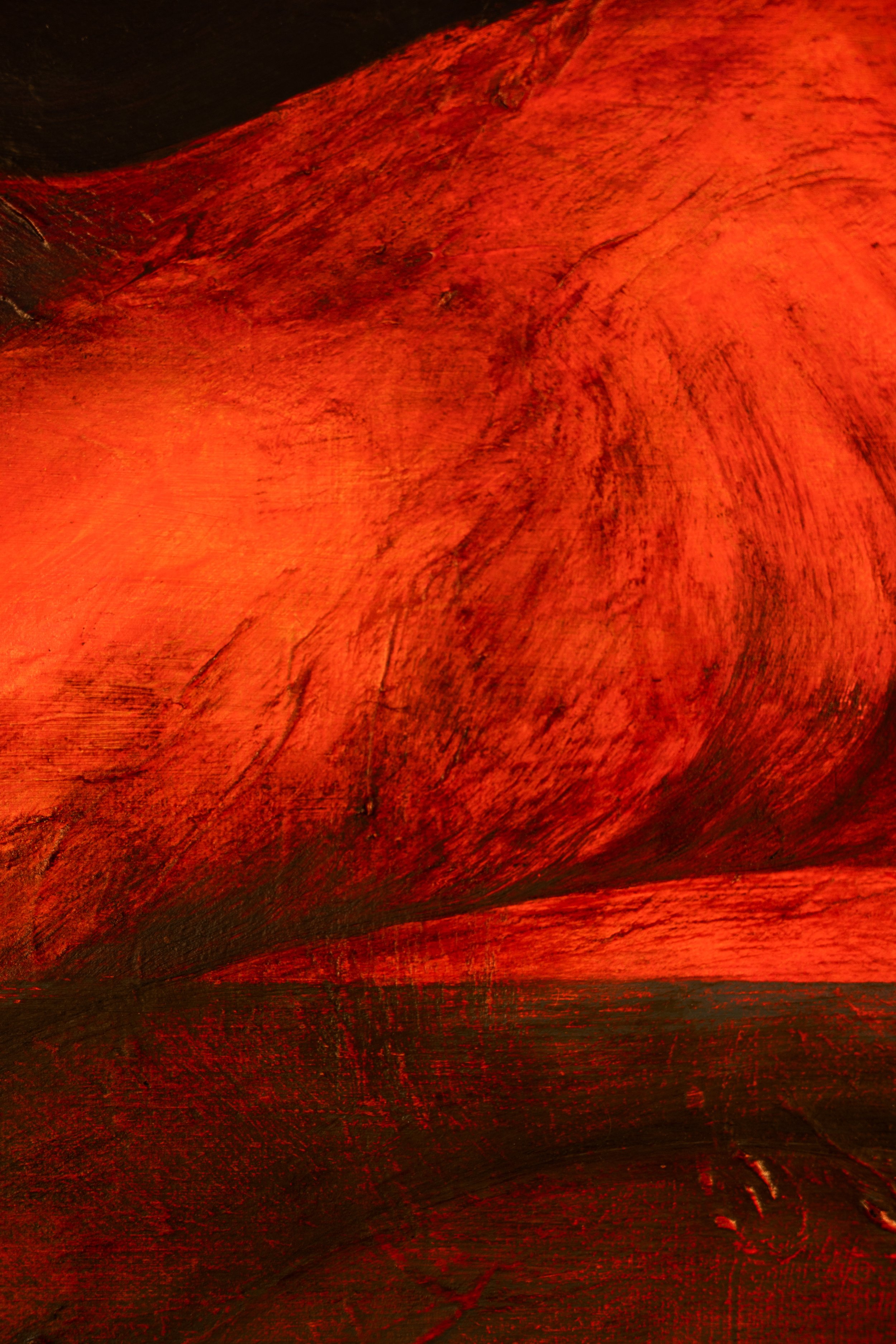 Close-up of a red-orange painted wooden surface with visible brushstrokes and wood grain.