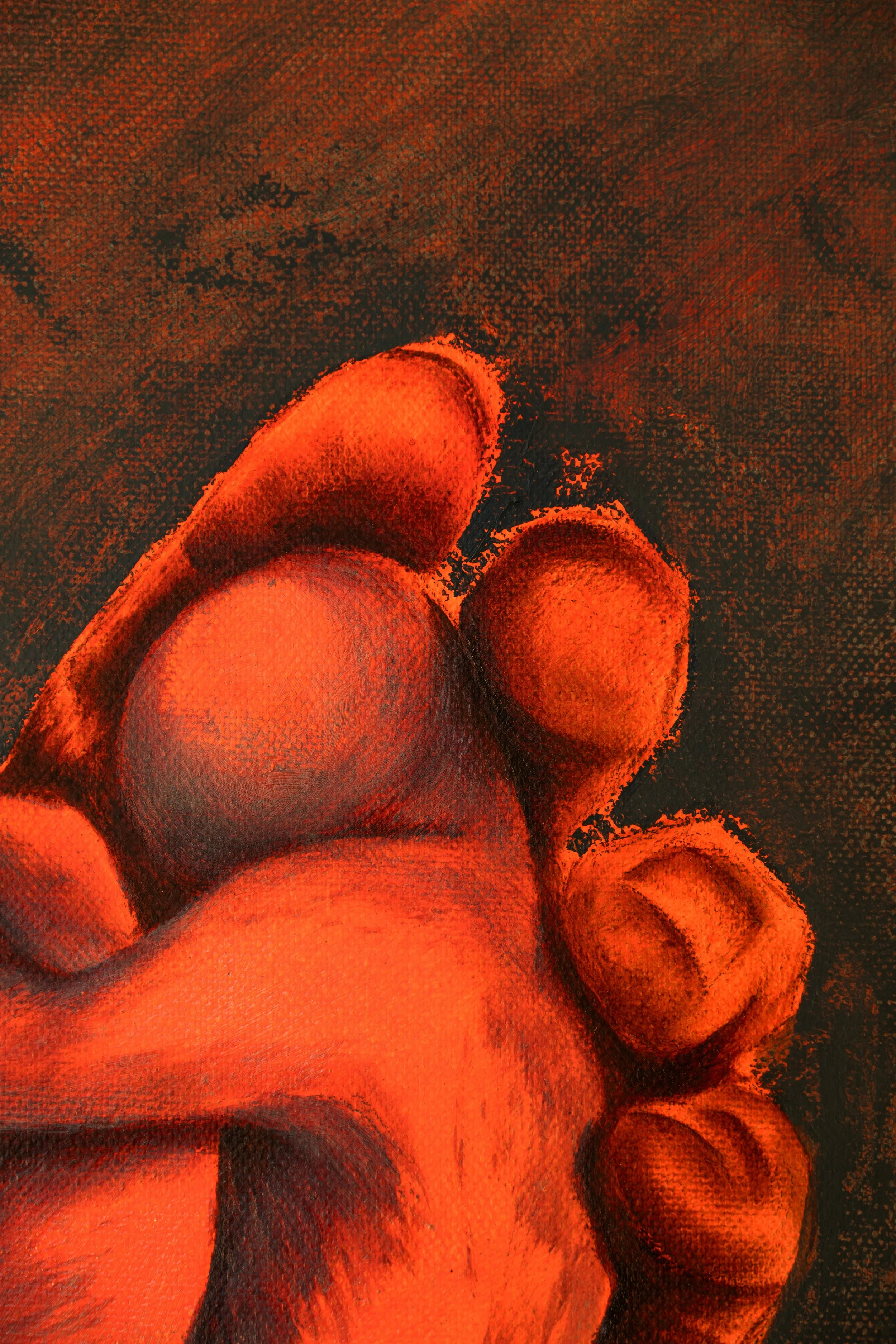 A close-up image of a human hand with clenched fingers, highlighted in reddish-orange tones.