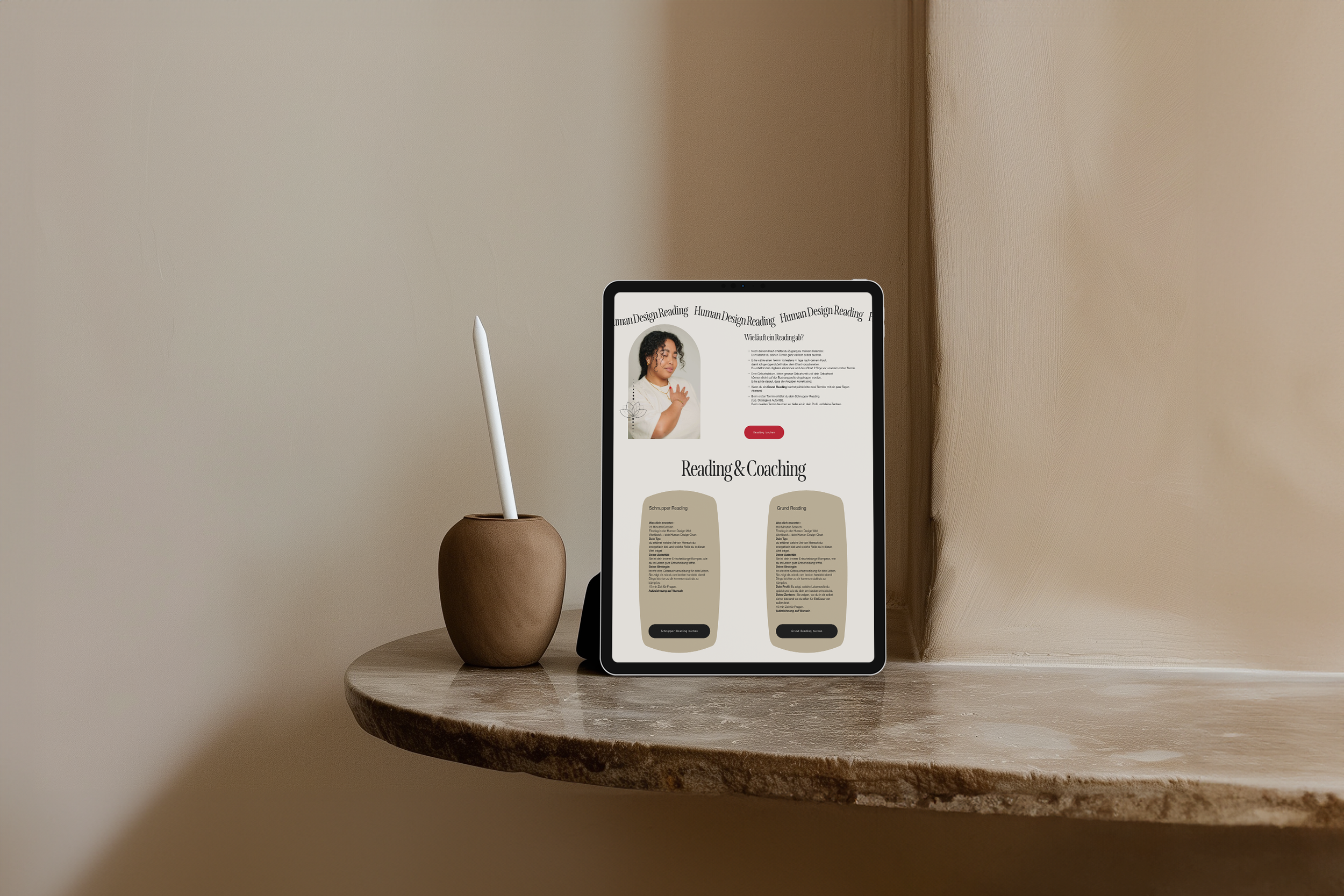 Ein Tablet auf einem runden Holztisch, daneben eine braune Vase mit einem Stift, zeigt eine Webseite über Lesen und Coaching. Im Hintergrund eine beige Wand.