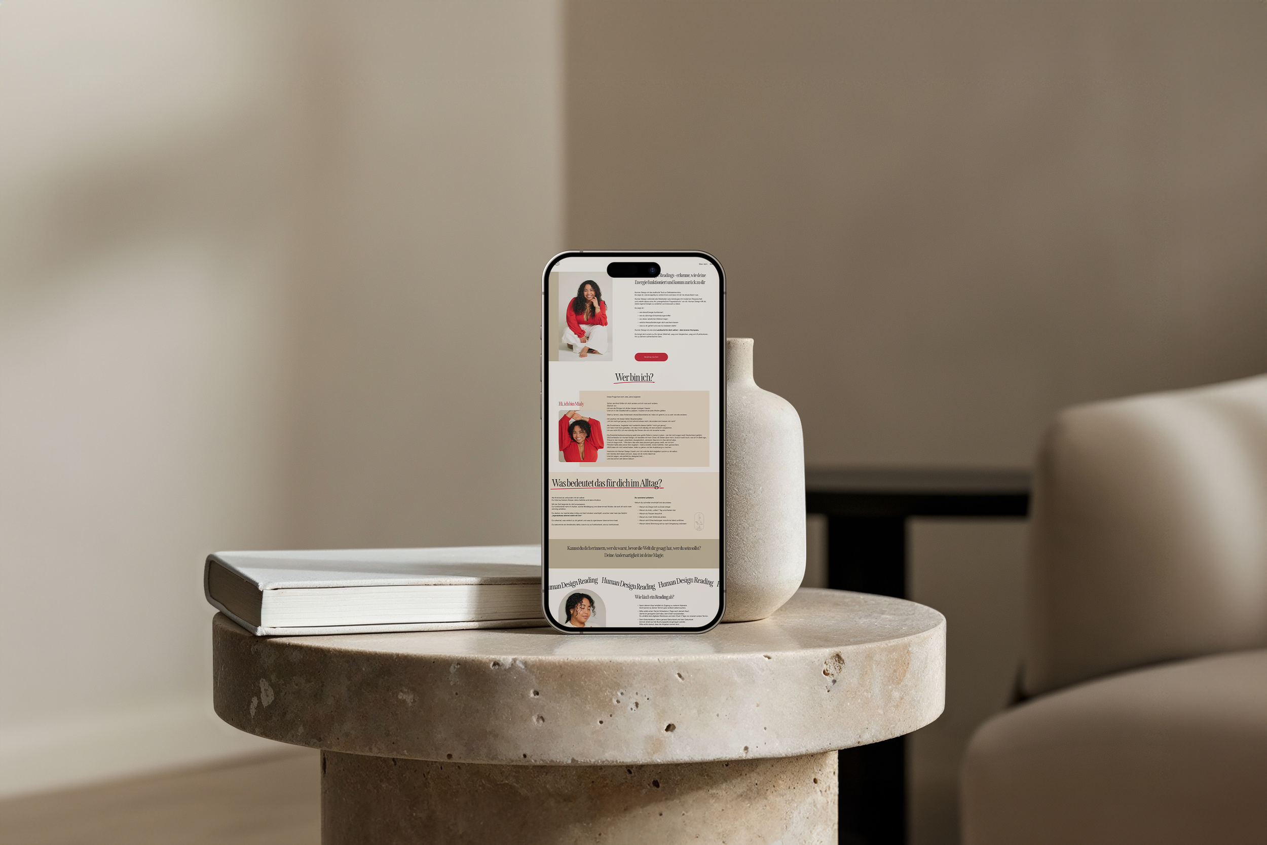 Ein Smartphone steht auf einem runden, Steinelement, das auf einem weißen Tisch liegt, mit einer Webseite auf dem Bildschirm. Die Umgebung ist minimalistisch mit neutralen Wandfarben.