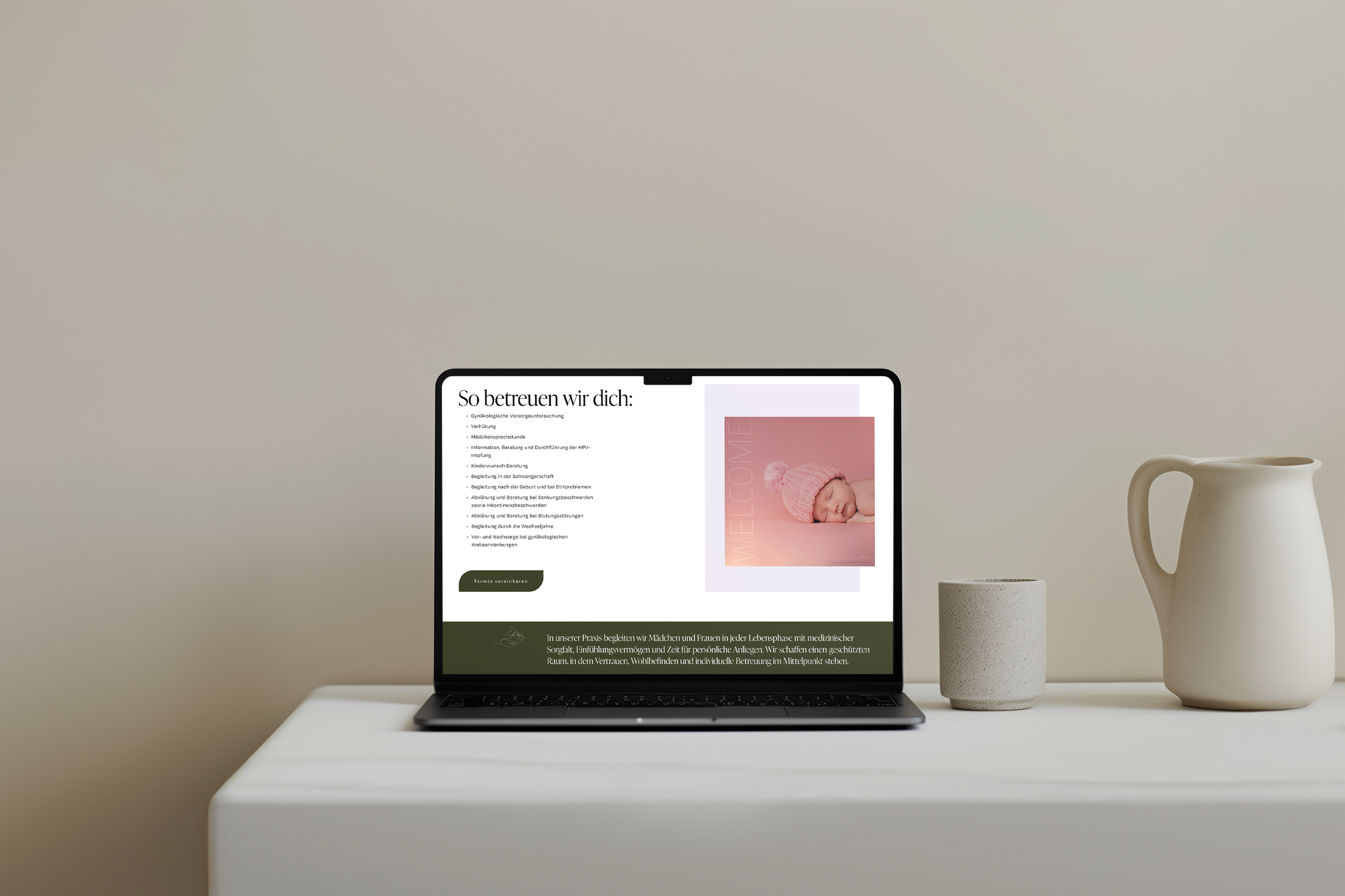 Ein Laptop auf einem weißen Tisch zeigt eine Webseite für gynäkologische Vorsorgeuntersuchungen, begleitet von Keramikvasen und Tassen auf dem Tisch, vor neutraler Wand.