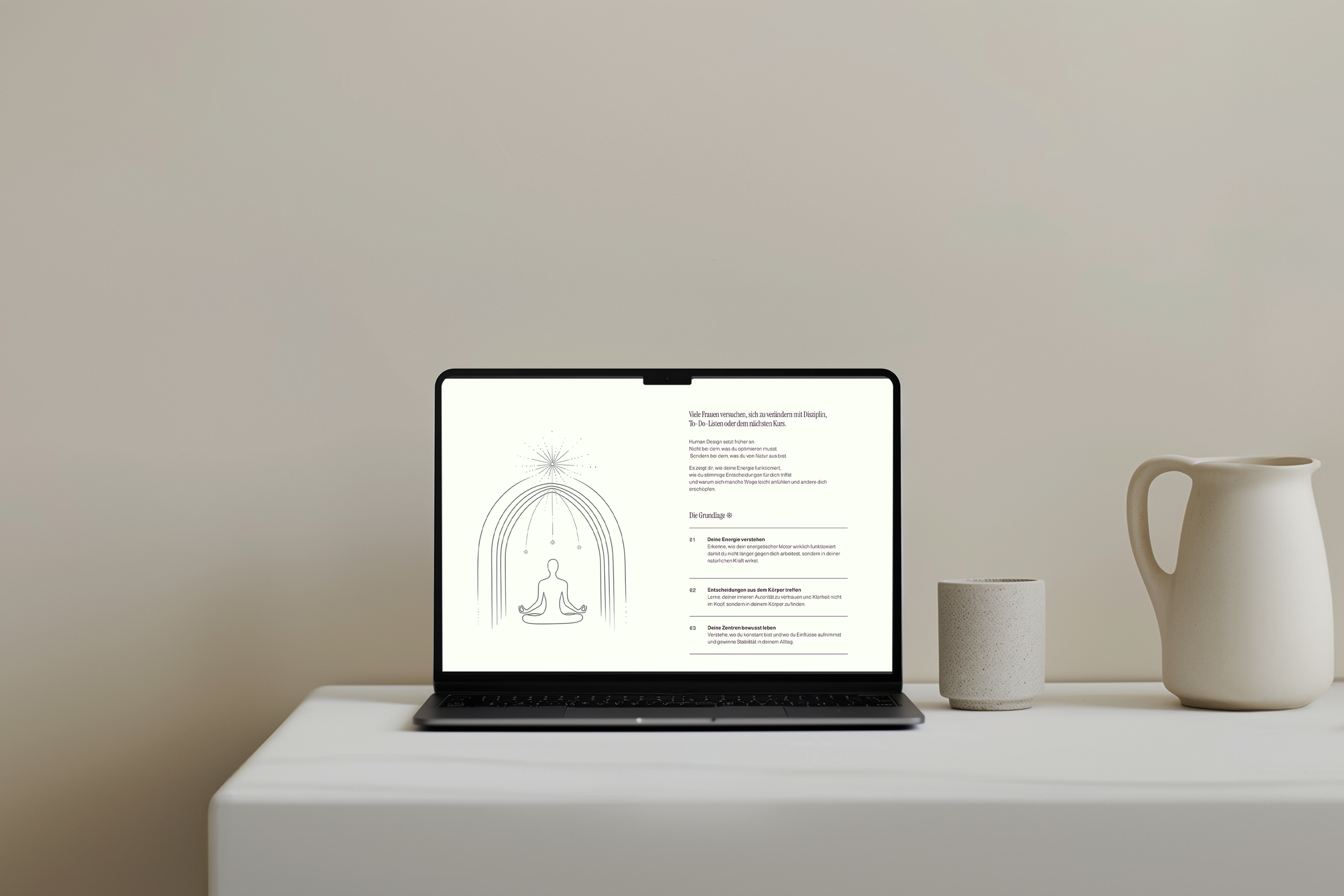 Ein Laptop auf einem weißen Tisch zeigt eine Webseite über Energie und Meditation, umgeben von keramischen Vasen auf der rechten Seite.