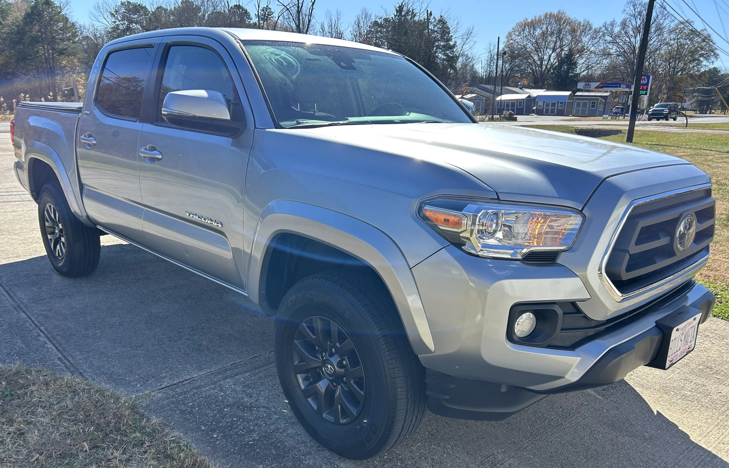A silver Toyota Tacoma pickup truck parked on a concrete driveway