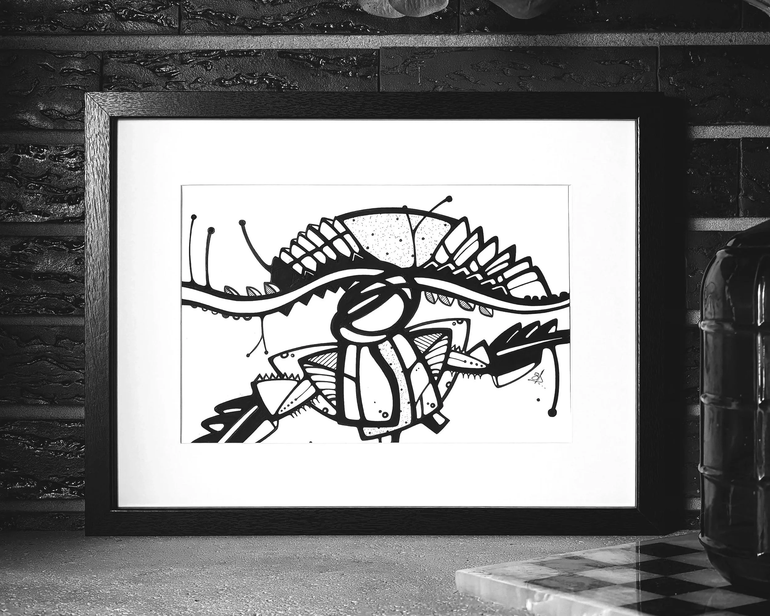 Une illustration en noir et blanc d'une créature fantastique, avec des éléments détaillés, encadrée et posée contre un mur en briques.