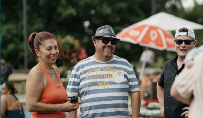 a group of people smiling and laughing while talking to each other