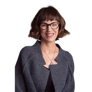 a woman wearing glasses and a sweater smiling