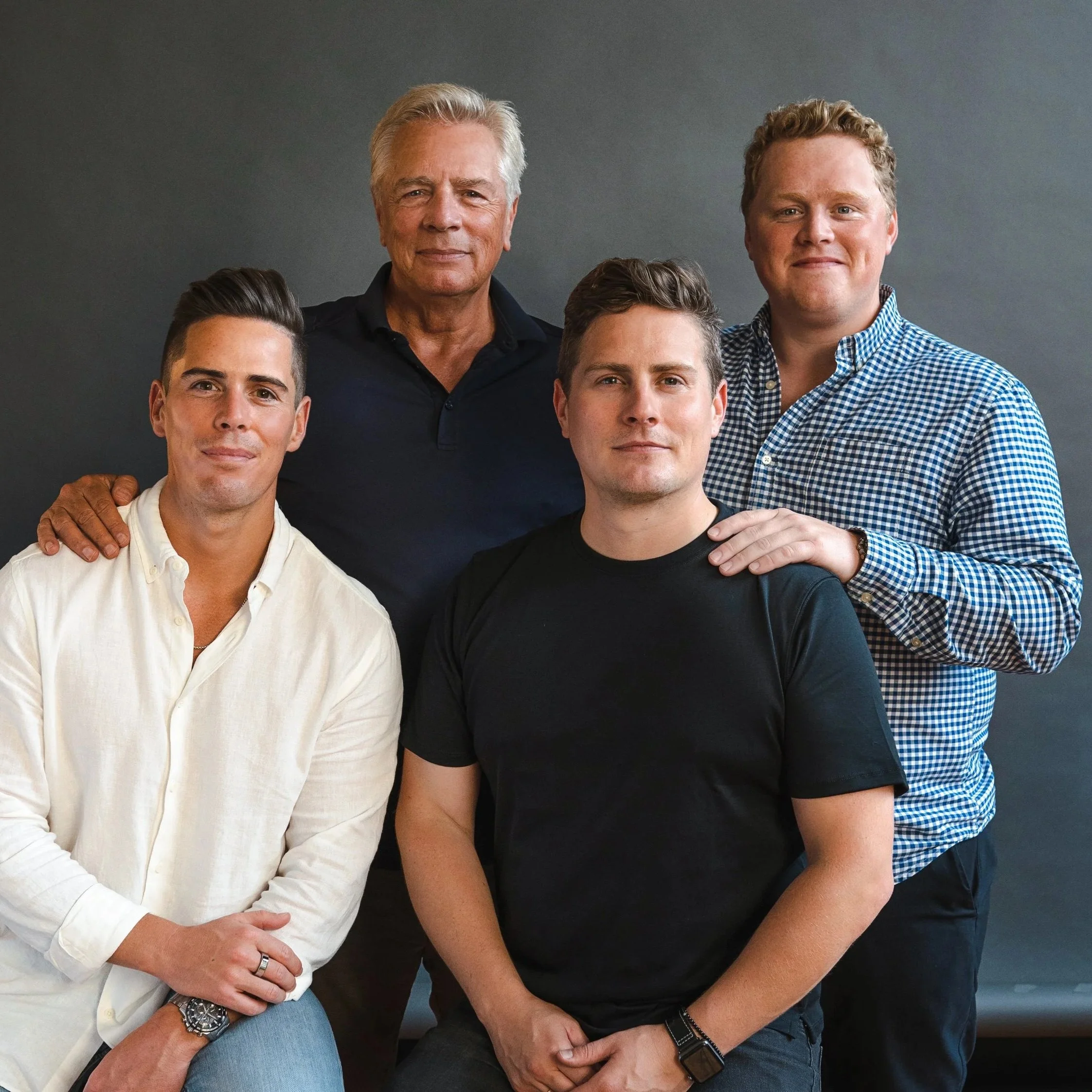 four men posing together and smiling