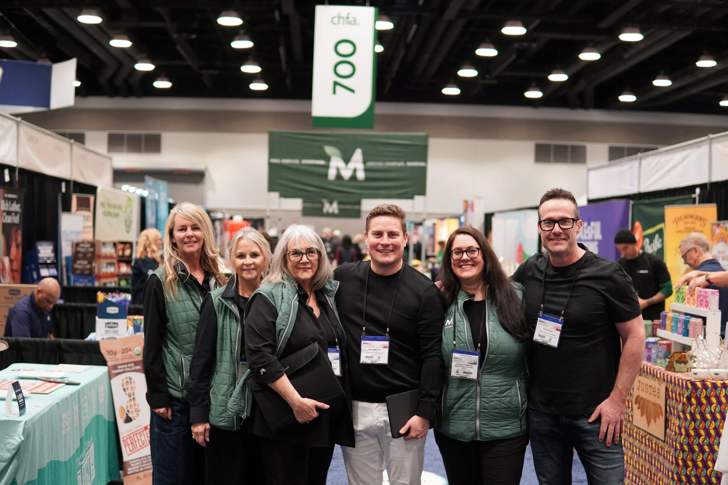 a group of people smiling and posing for a photo at a convention