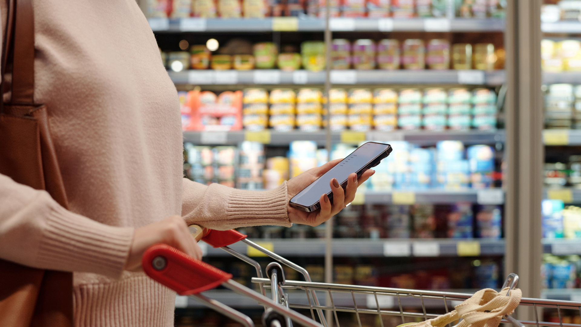 woman in a grocery store holding a cell phone