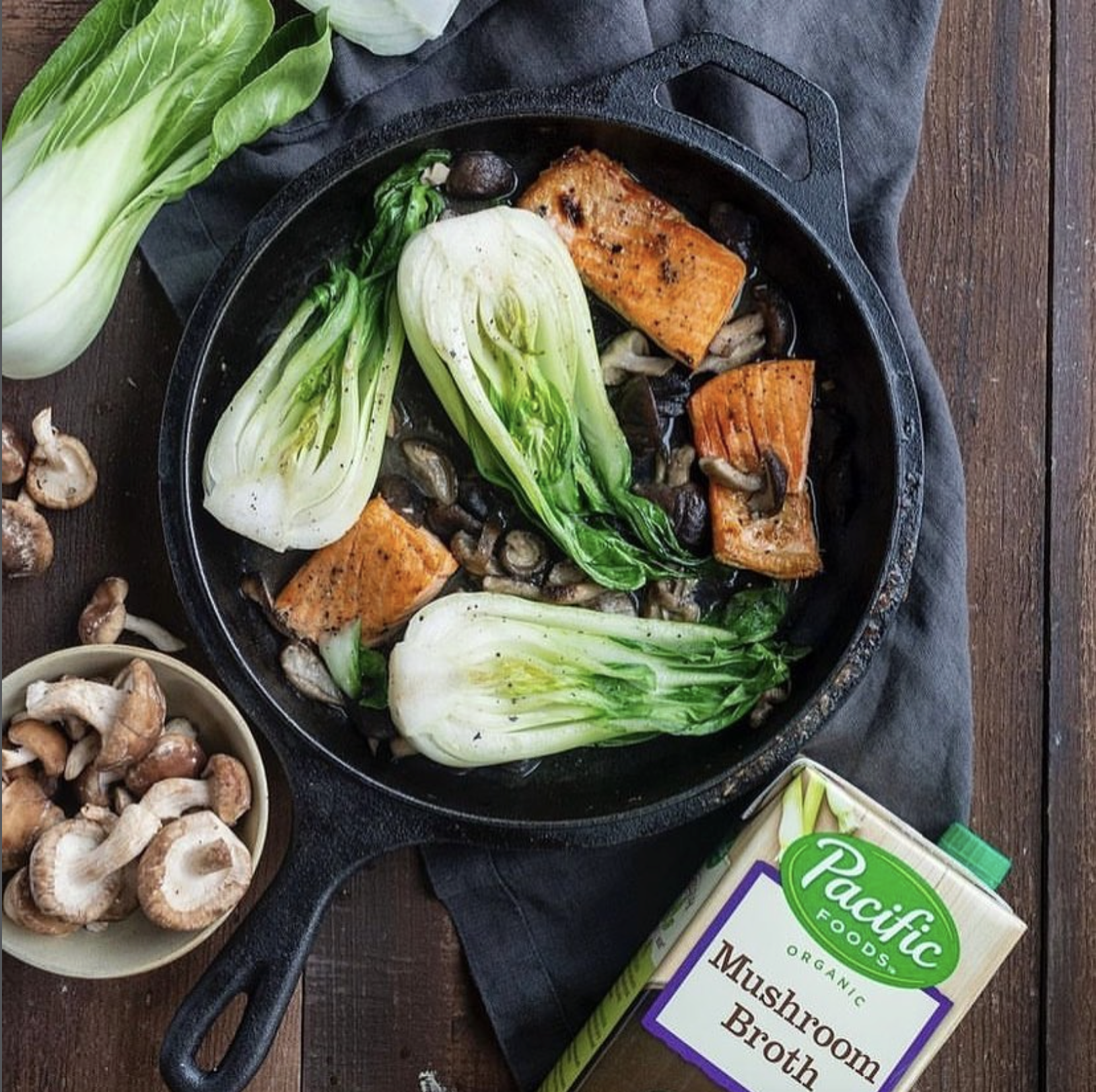 food dish in a pan with a box of Pacific Foods mushroom broth on the side