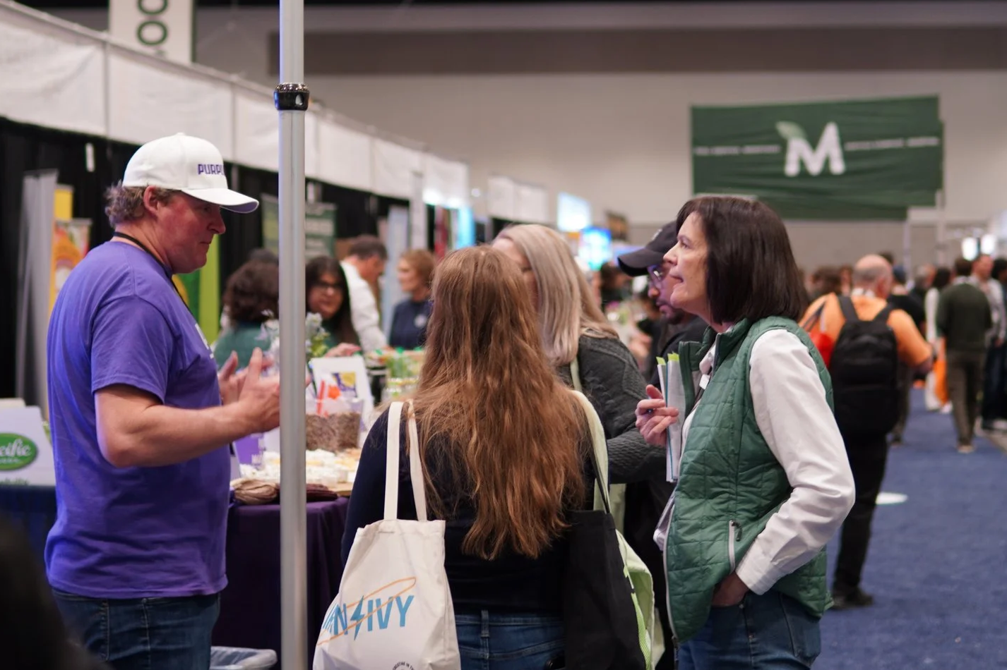 a group of people talking to each other at a convention