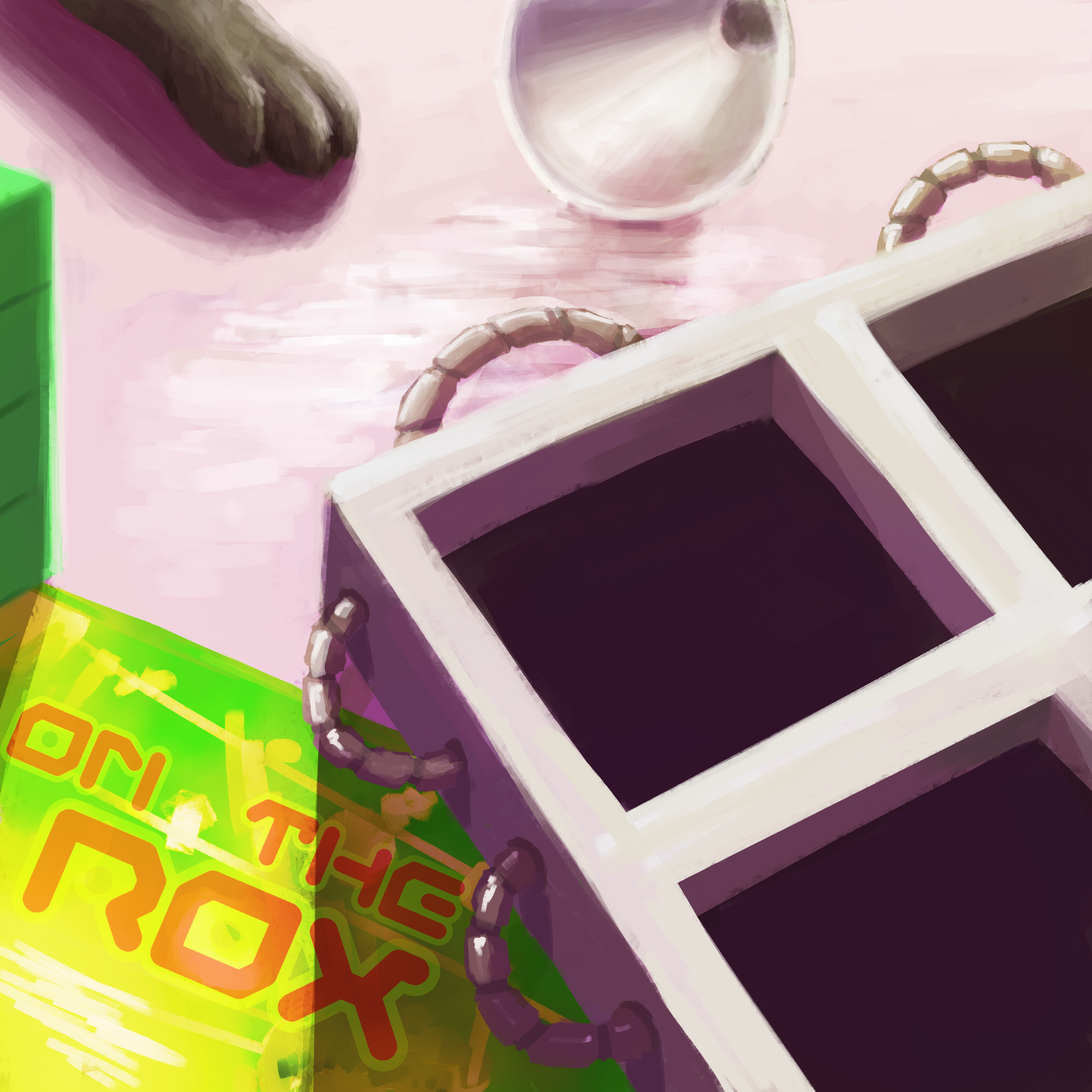 A close-up of a gaming desk setup with two black computer monitors, a beaded bracelet, a crystal ball, a gray cat paw, and a colorful box that reads 'Dirtbox'.