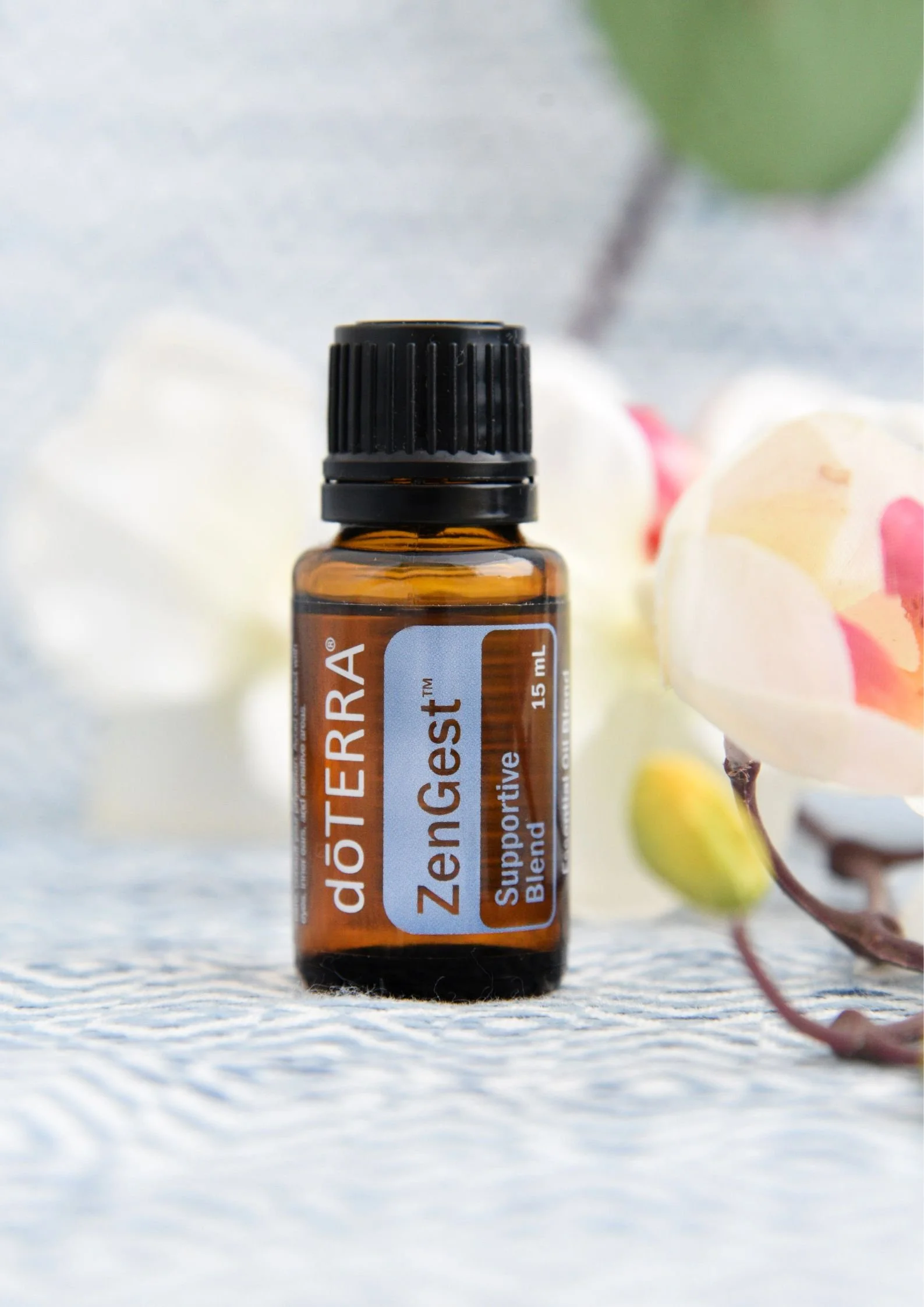 Boccetta di miscela digestiva ZenGest doTERRA su base chiara con disegni geometrici e fiori chiari di lato - Silvia Pagliarini